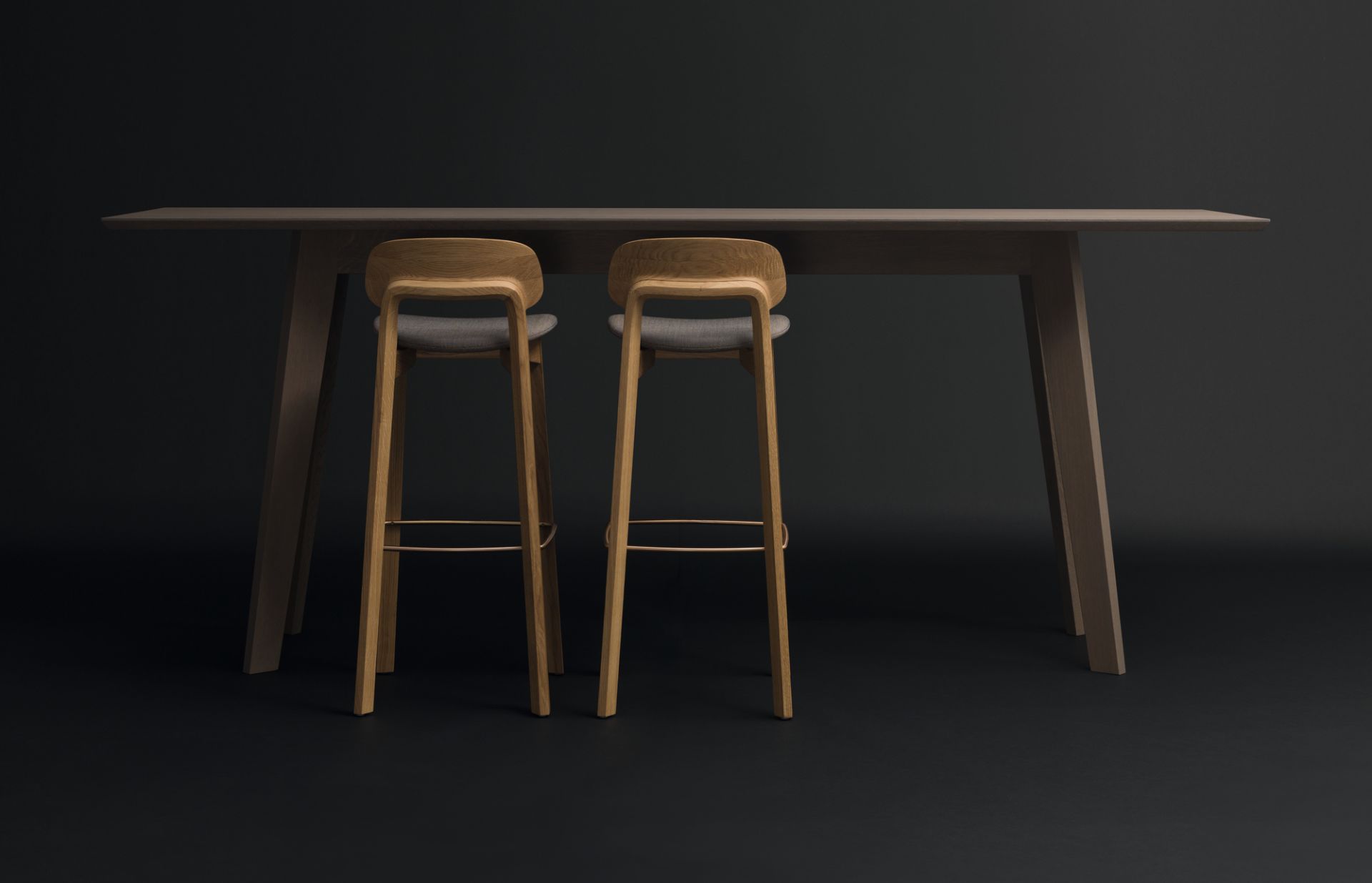 Zwei Nonoto Barhocker aus Nussbaum mit grauen Sitzen an einem Bartisch.