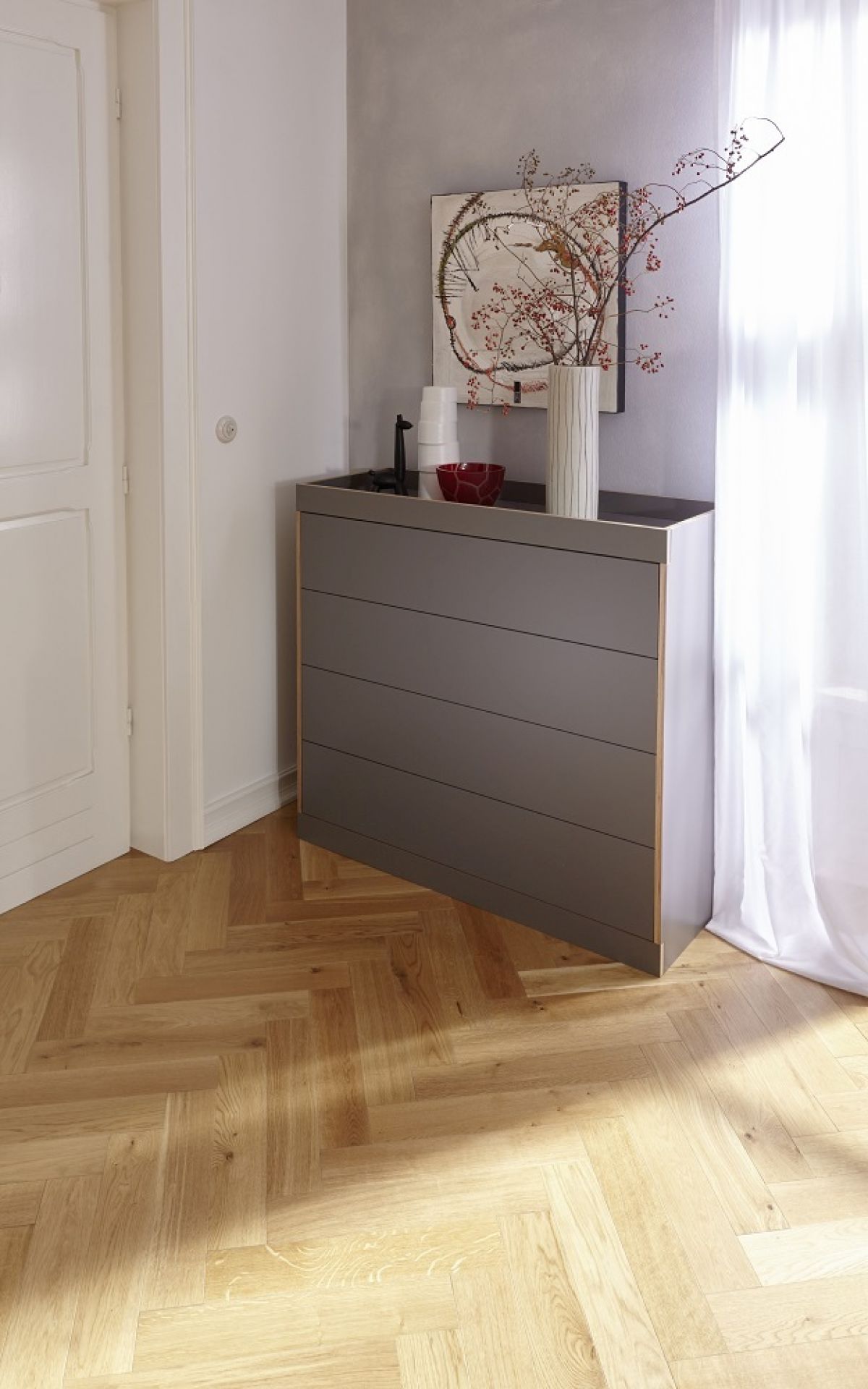 Graue Flai Kommode von Müller Möbelwerkstätten im modernen Wohnzimmer mit Parkettboden.
