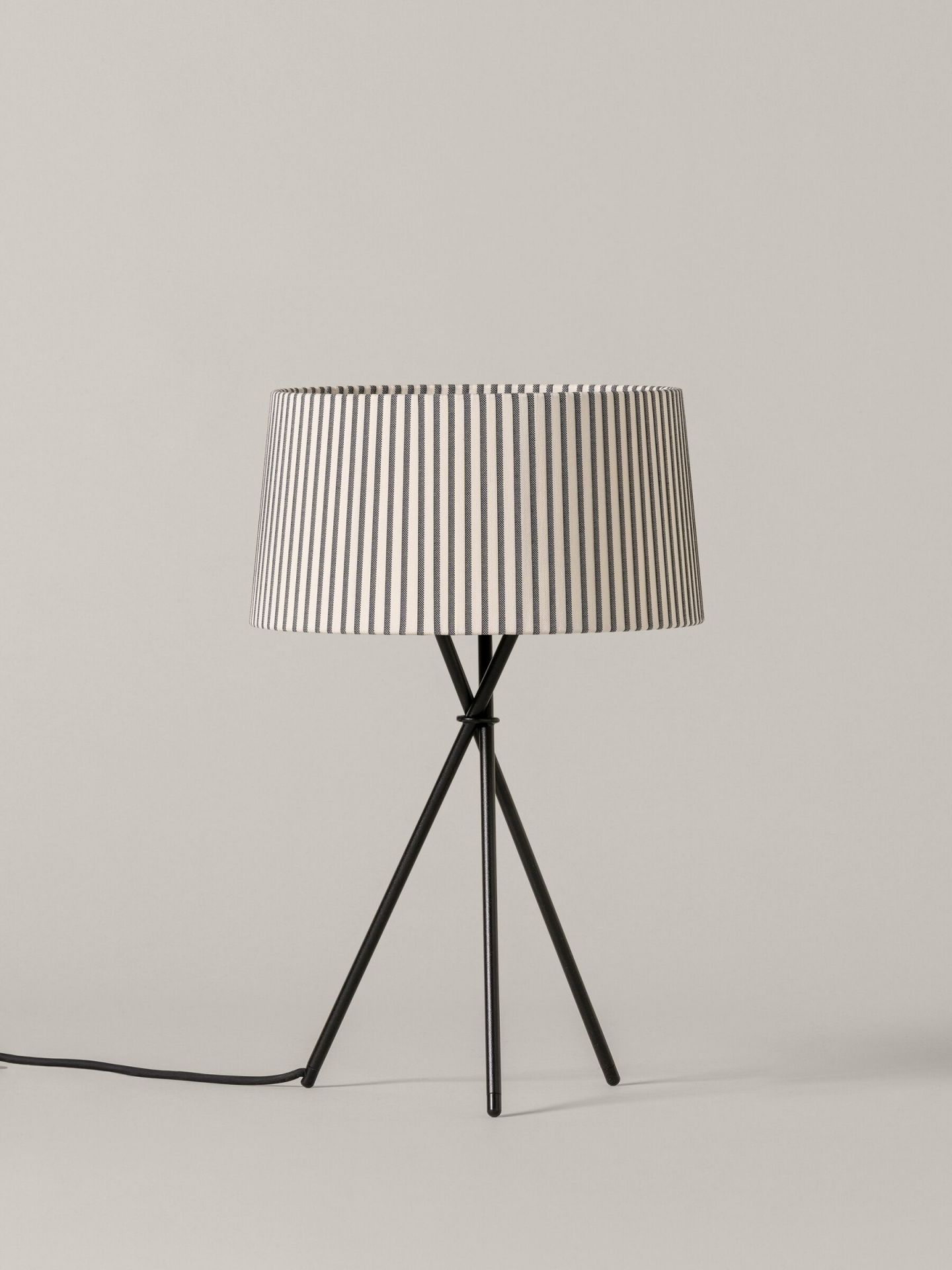 Tripode M3 Tischleuchte mit Bretona Stripes Schirm von Santa & Cole auf schwarzem Stativfuß.