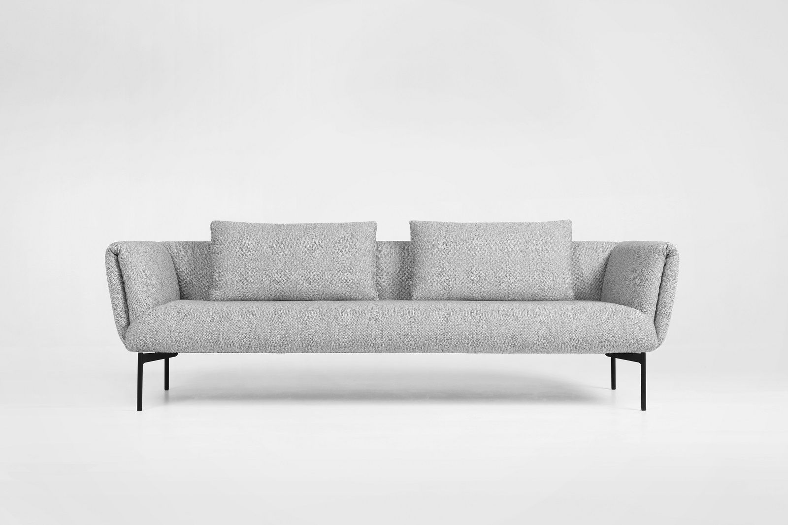 Graues Prostoria Impression Sofa mit zwei Kissen und schwarzen Füßen auf weißem Hintergrund.