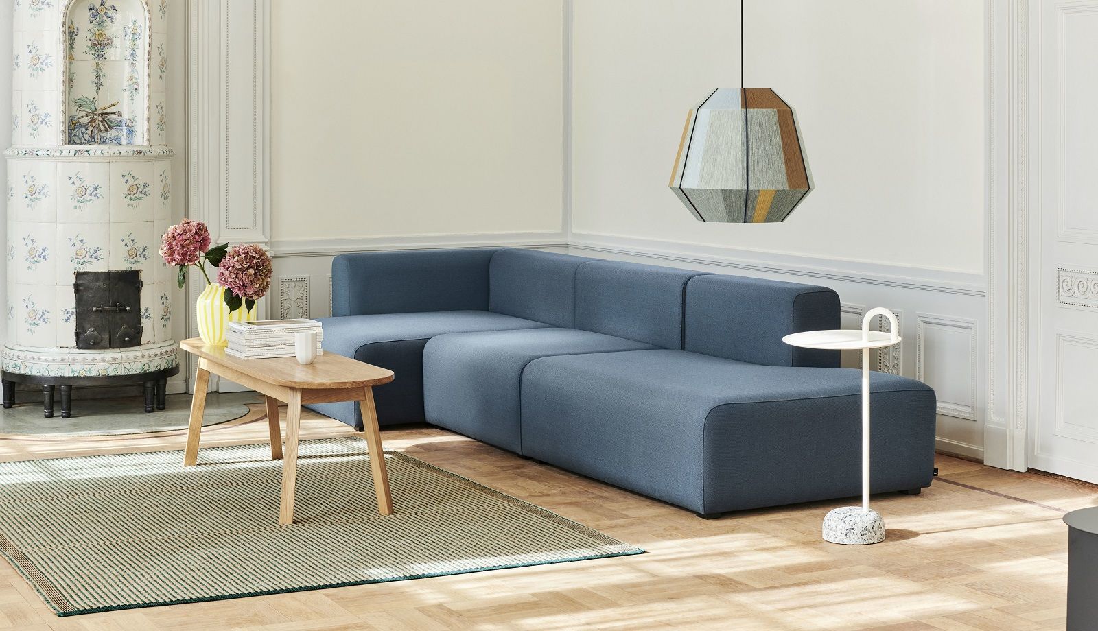 Wohnzimmer mit blauem Sofa und weißem Hay Bowler Beistelltisch mit Marmorfuß.