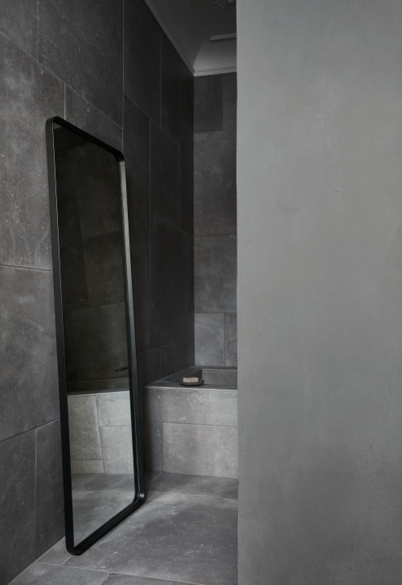 Norm Floor Mirror von Audo, ein großer, schwarzer Standspiegel im modernen Badezimmer.