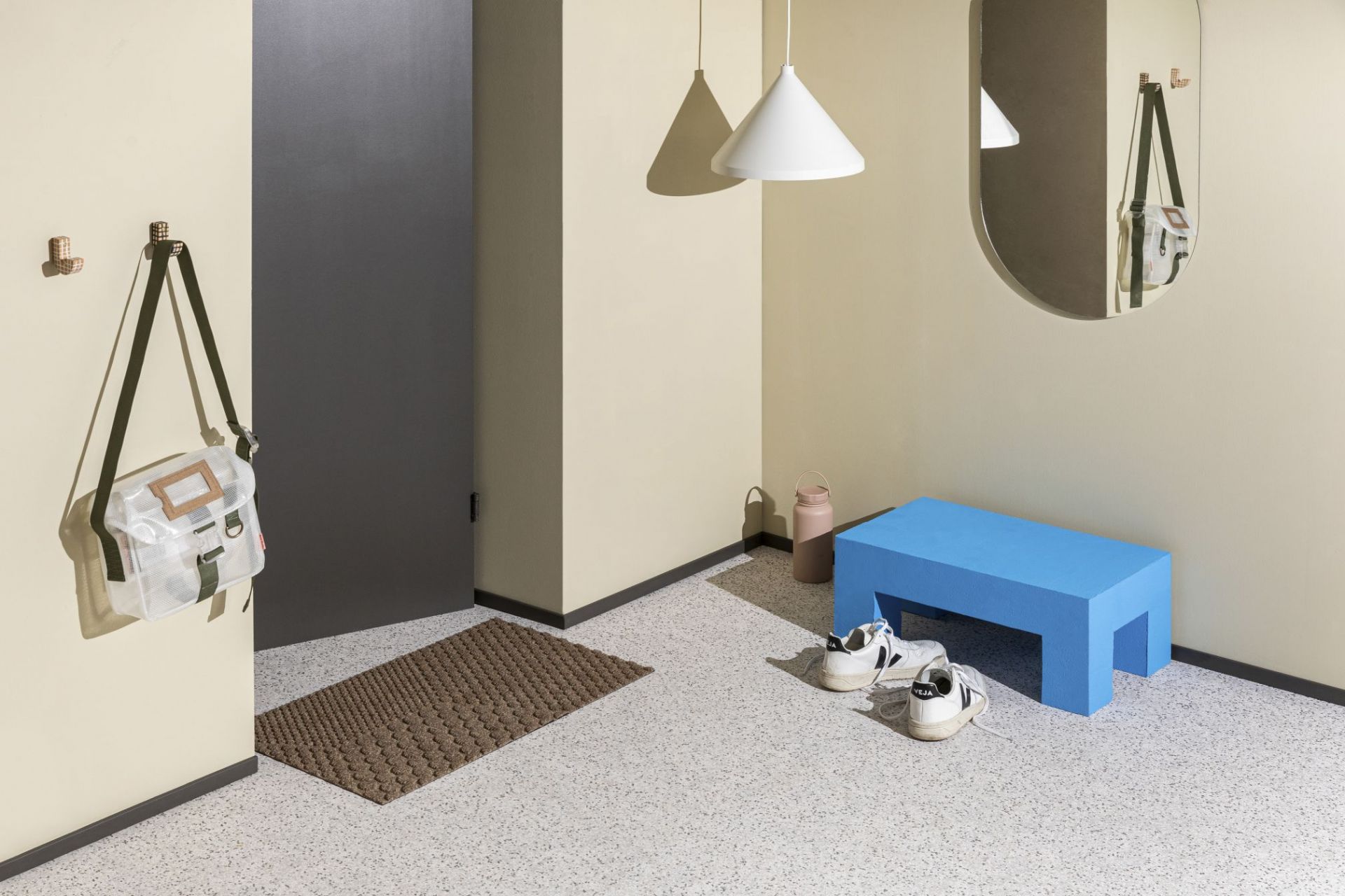 Braune Heymat Fußmatte "Desert" vor einer Tür, im Flur mit Bank und Dekoration.