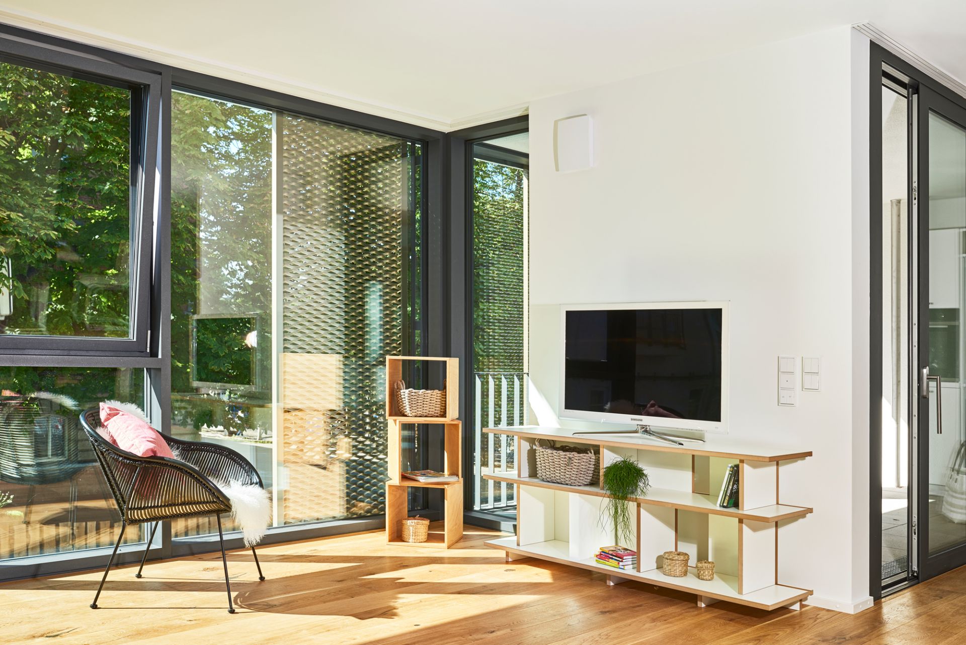 Helles Wohnzimmer mit Tojo Regal Anbaumodul aus Holz, kombiniert mit TV-Möbel und Dekoration.