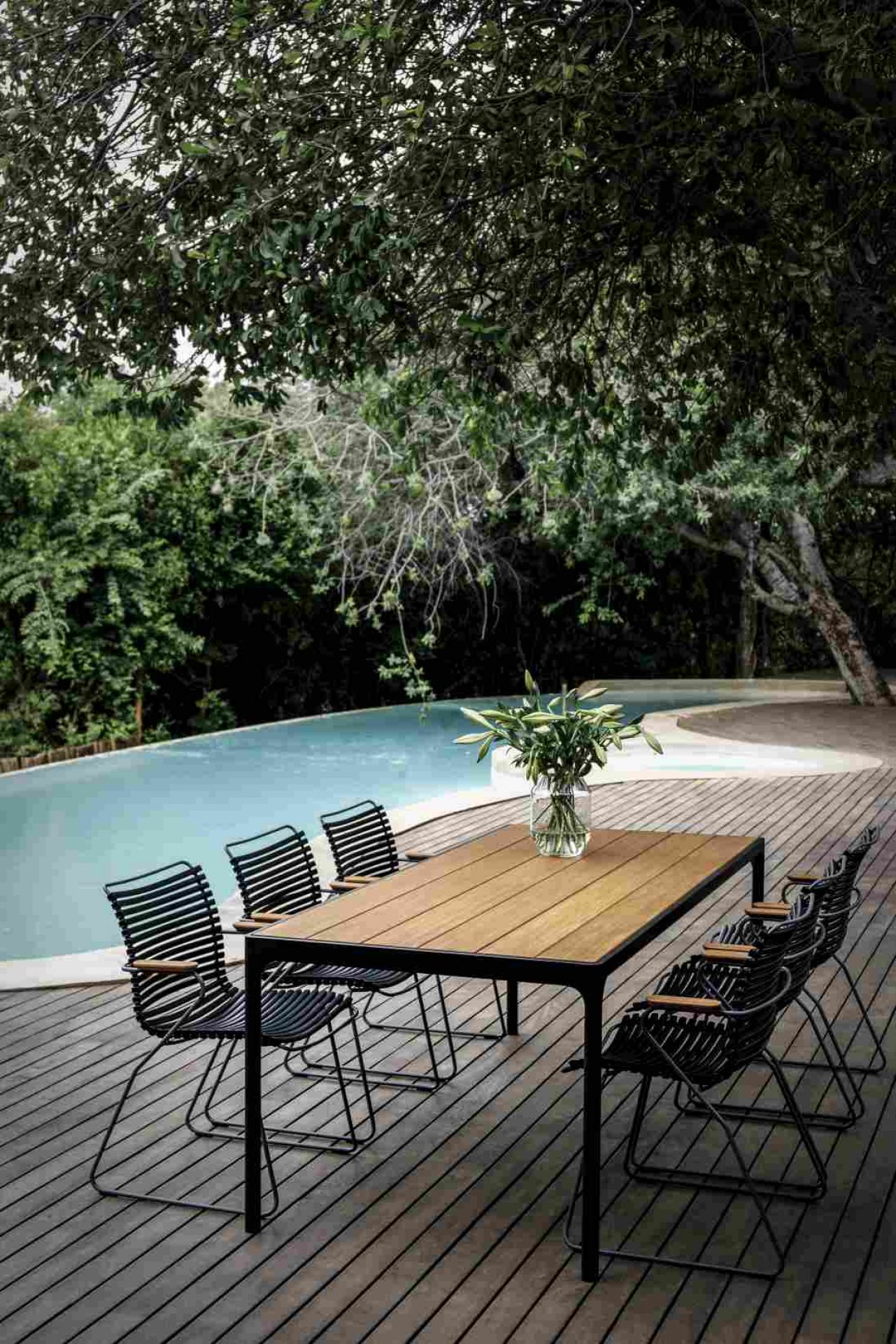 Houe Four Dining Esstisch Outdoor mit Stühlen auf Holzterrasse neben Pool. Gartenmöbel für Draußen.