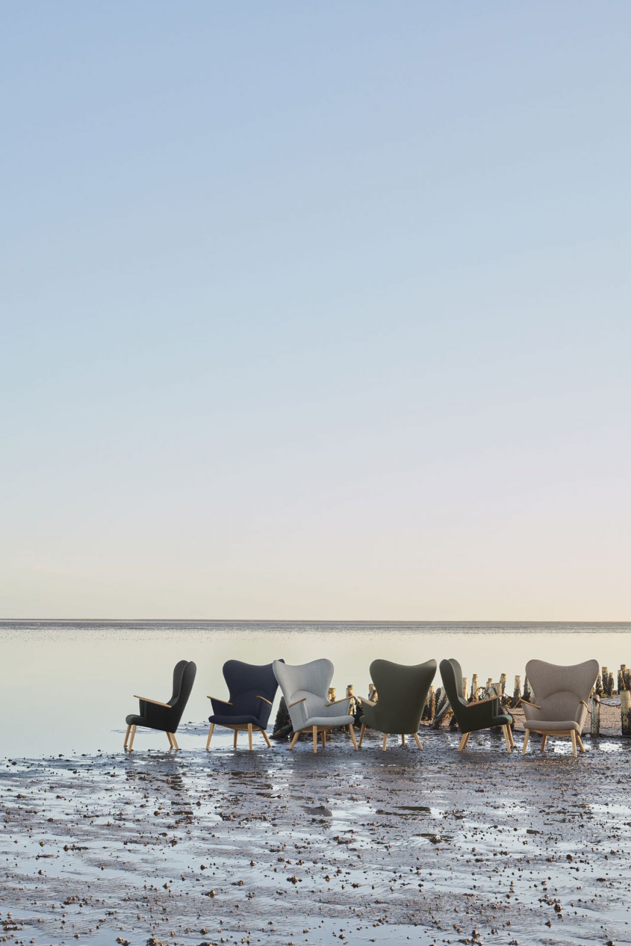 CH78 Mama Bear Sessel von Carl Hansen & Søn in verschiedenen Farben am Strand.