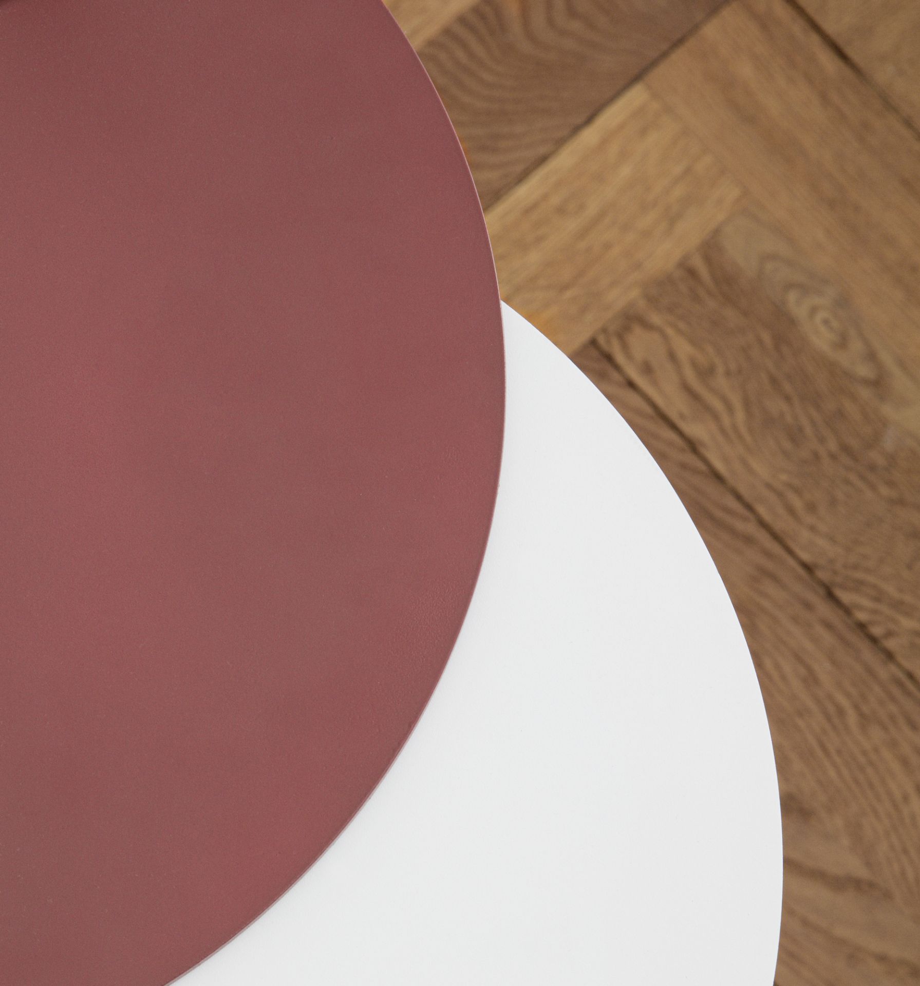 Detailaufnahme: Normann Copenhagen Stock Table Beistelltisch, runde Tischplatten in Weiß und Rotbraun.