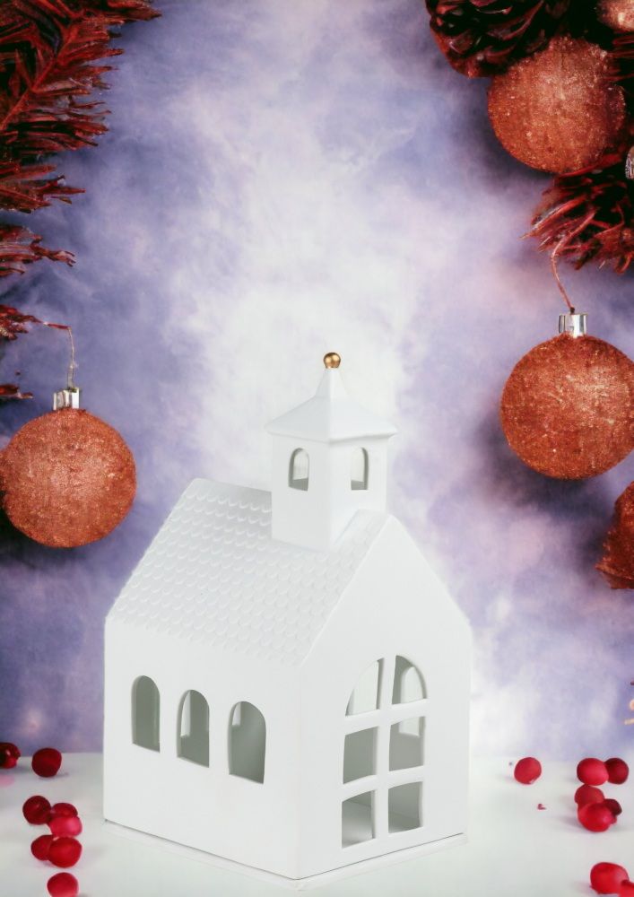 Großes, weißes Lichthaus in Kapellenform von Räder, umgeben von weihnachtlicher Dekoration.