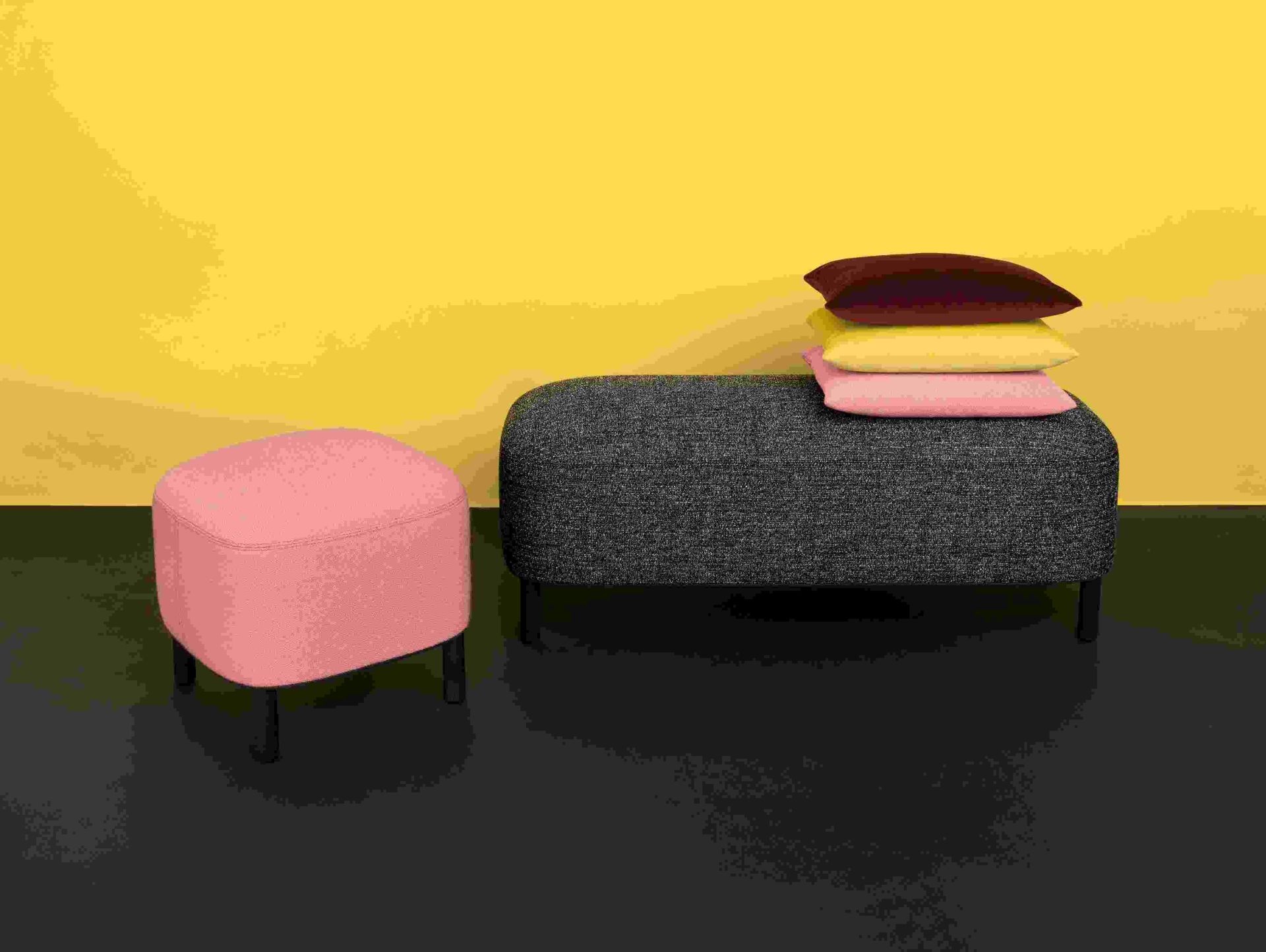 Amie Bank von Schönbuch mit Hocker und Kissen in verschiedenen Farben vor gelbem Hintergrund.