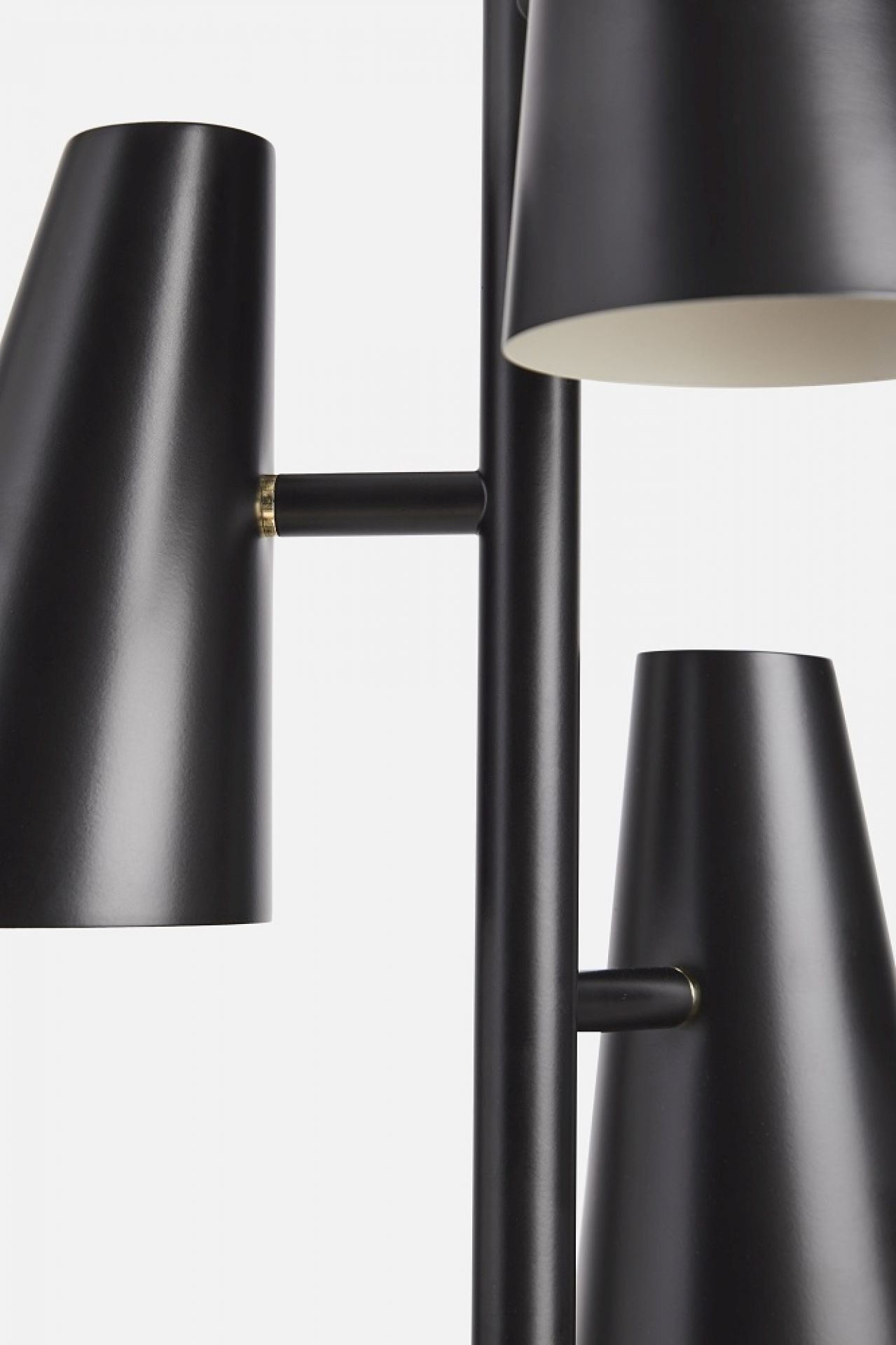 Detailaufnahme der Cono Pendelleuchte von Woud mit drei schwarzen Lampenschirmen.