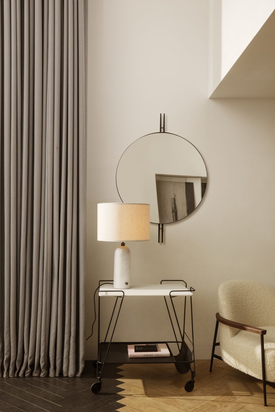 IOI Wandspiegel von Gubi: Runder Spiegel mit schwarzem Rahmen im modernen Wohnzimmer. Dekorative Wandspiegel für stilvolles Interieur.