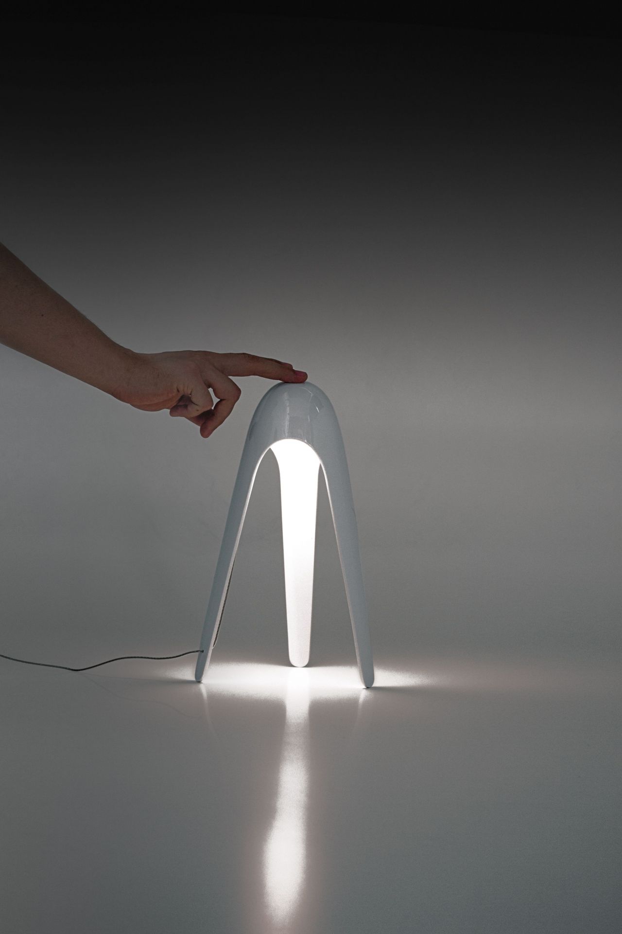 Hellblaue Cyborg Tischleuchte von Martinelli Luce mit Hand, die die Lampe berührt.