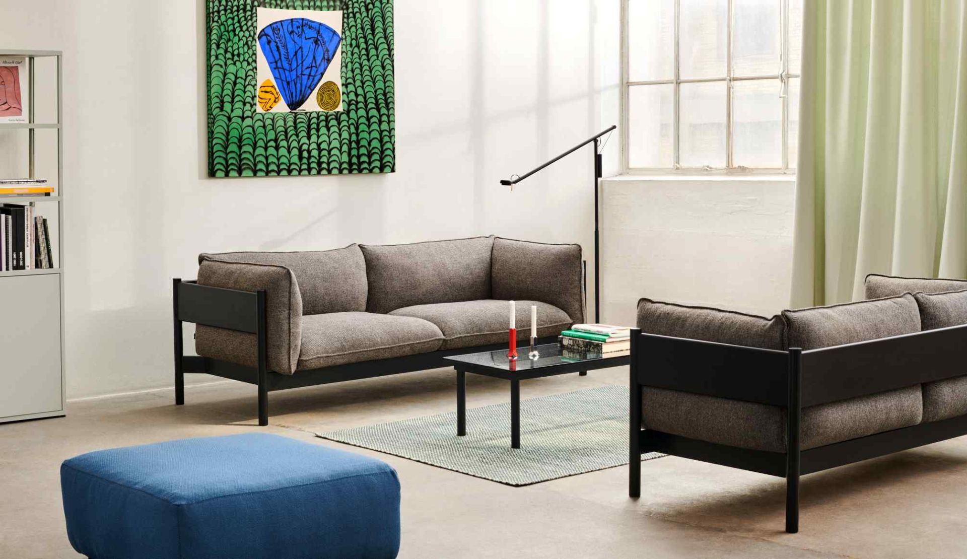 Wohnzimmer mit grauem Hay Sofa und blauem Mags Soft Ottoman, moderne Sitzmöbel und Teppich.