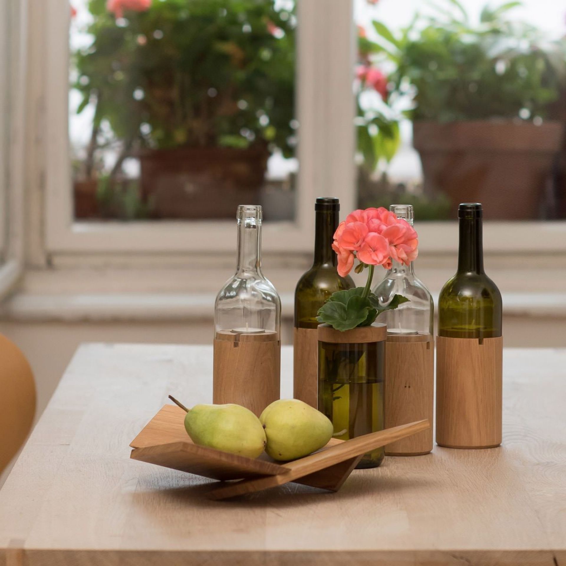 Grüne Side by Side Vase und Dosen als Tischdeko mit Blumen und Birnen auf Holztisch.