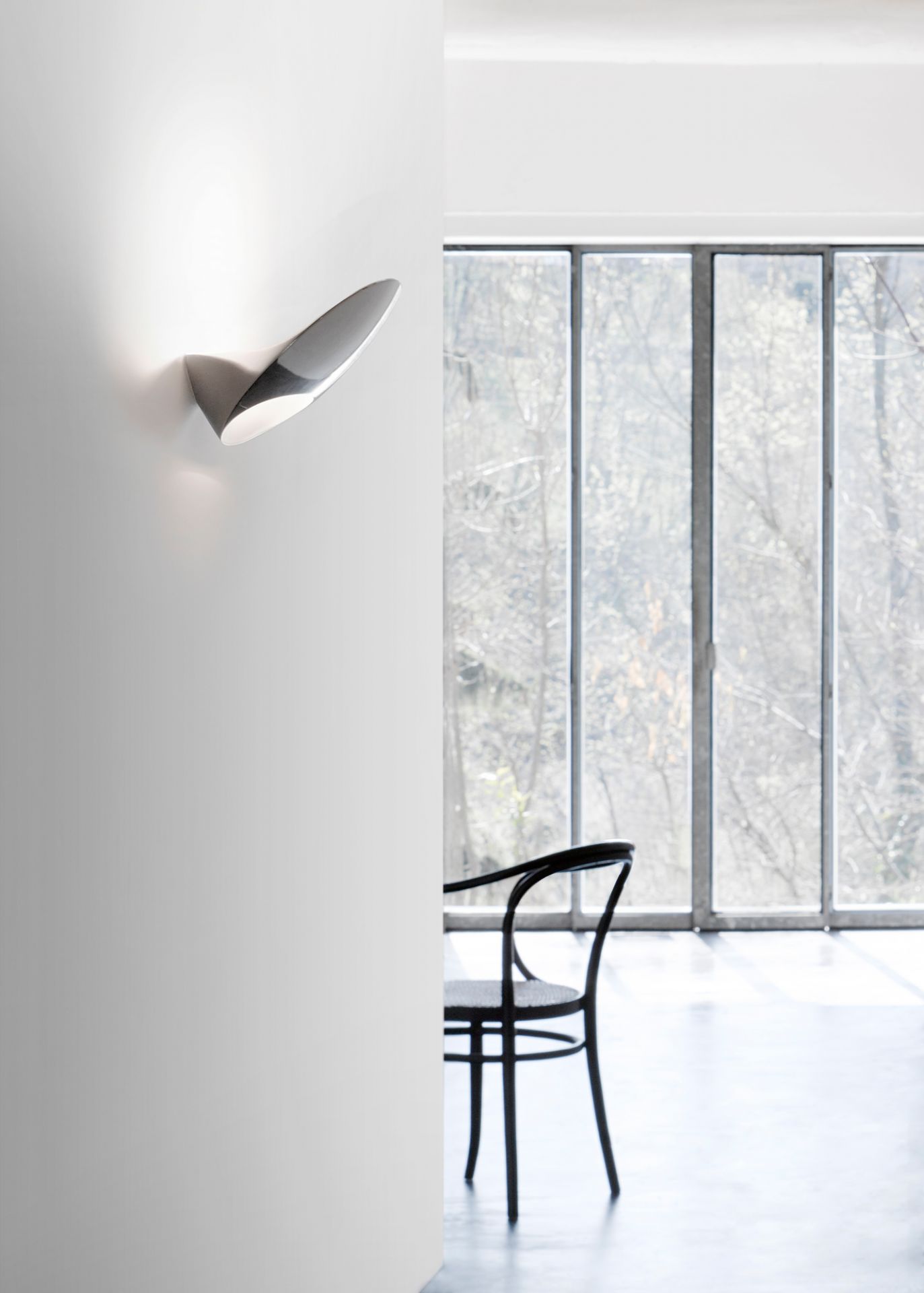 D90 Garbi Wandleuchte von Luceplan, modernes Design, indirekte Beleuchtung, silberfarben, an weißer Wand montiert.