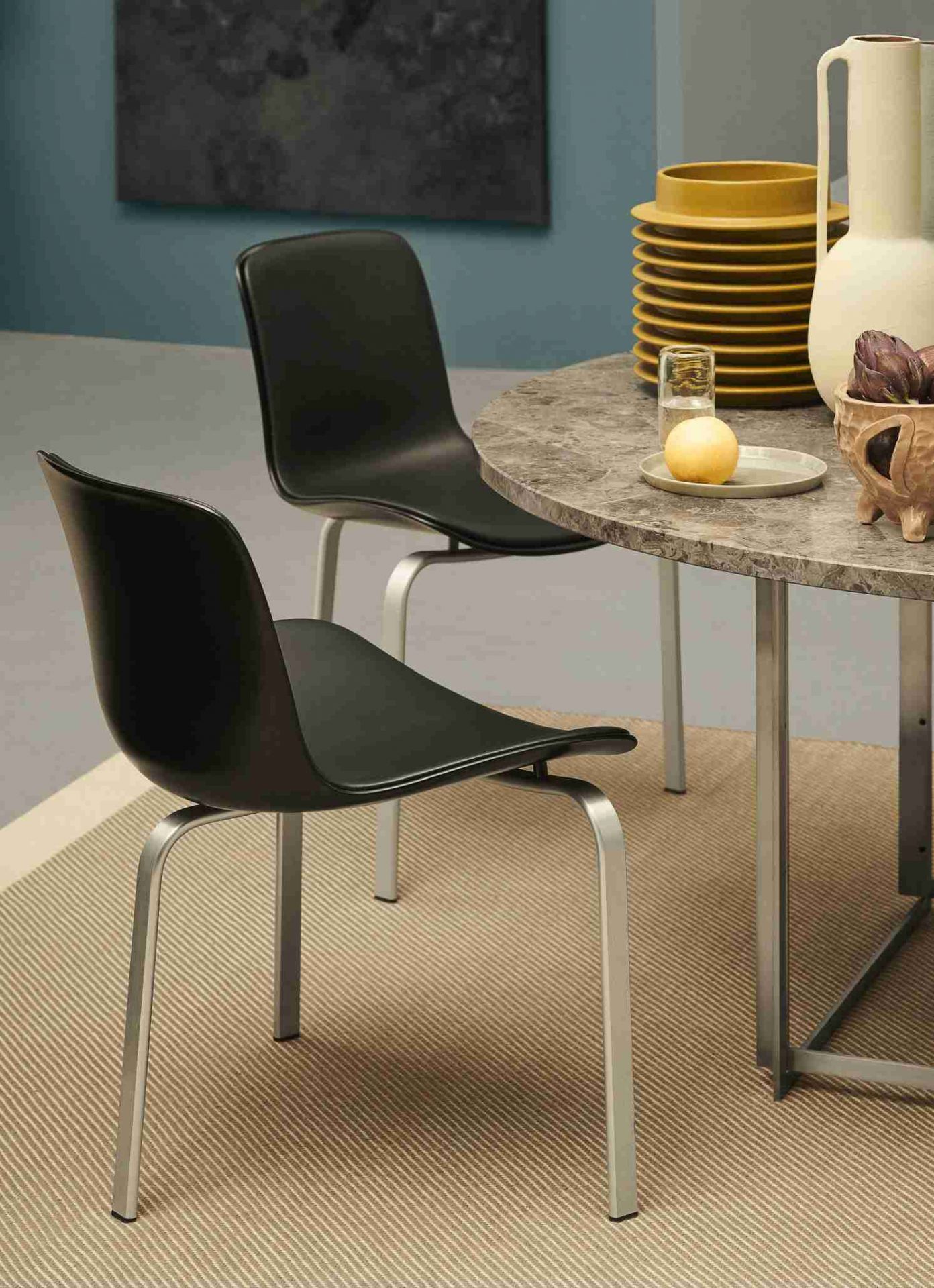 Zwei schwarze PK8 Stühle von Fritz Hansen an einem runden Marmortisch. Designermöbel für Esszimmer.