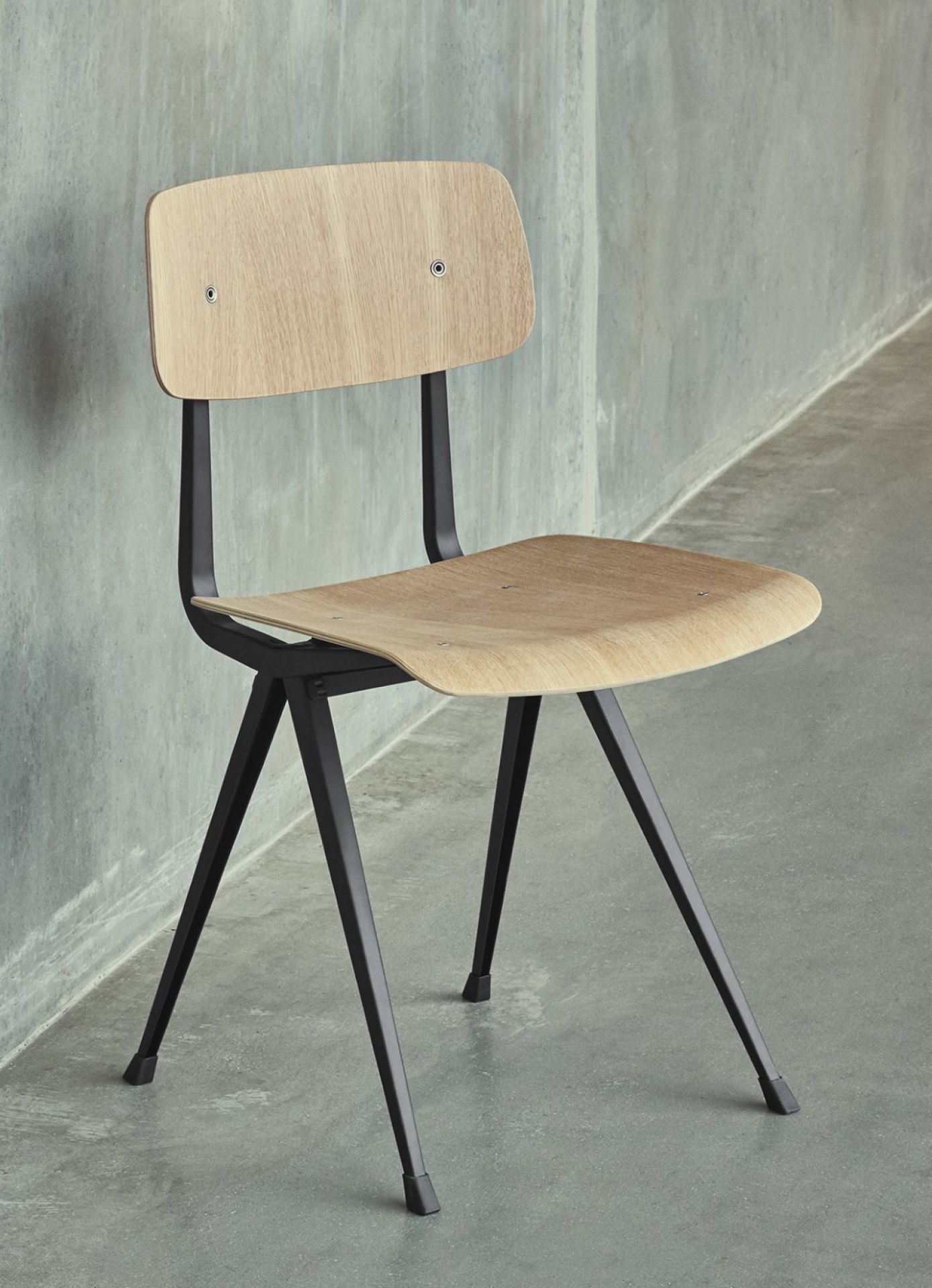 Hay Result Chair mit Eichenholz Sitzfläche und schwarzem Stahlgestell, ein moderner Designstuhl.