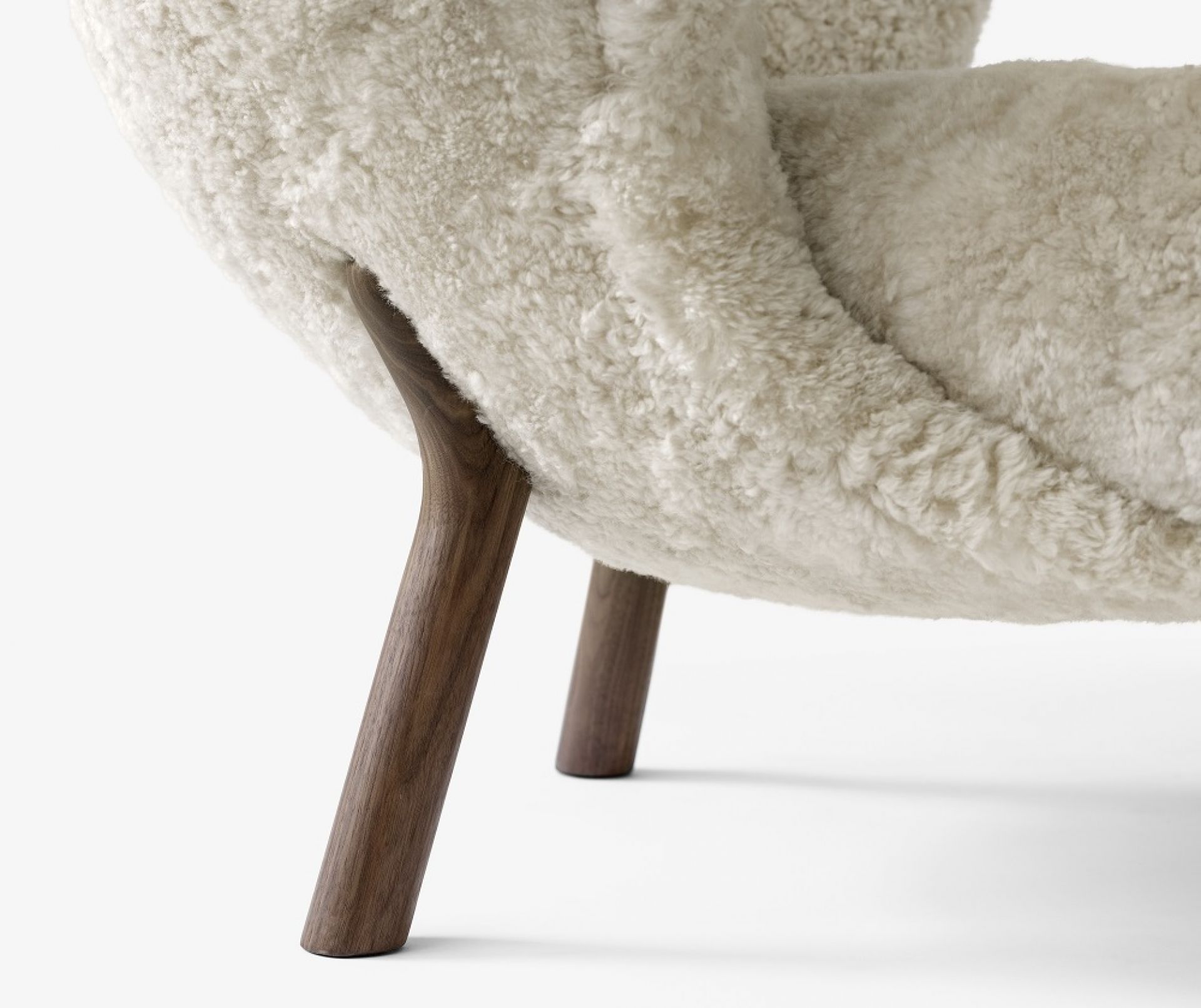 Detailaufnahme: Little Petra Sessel mit Eichenfüßen und weißem Schaffellbezug. Design Sessel.