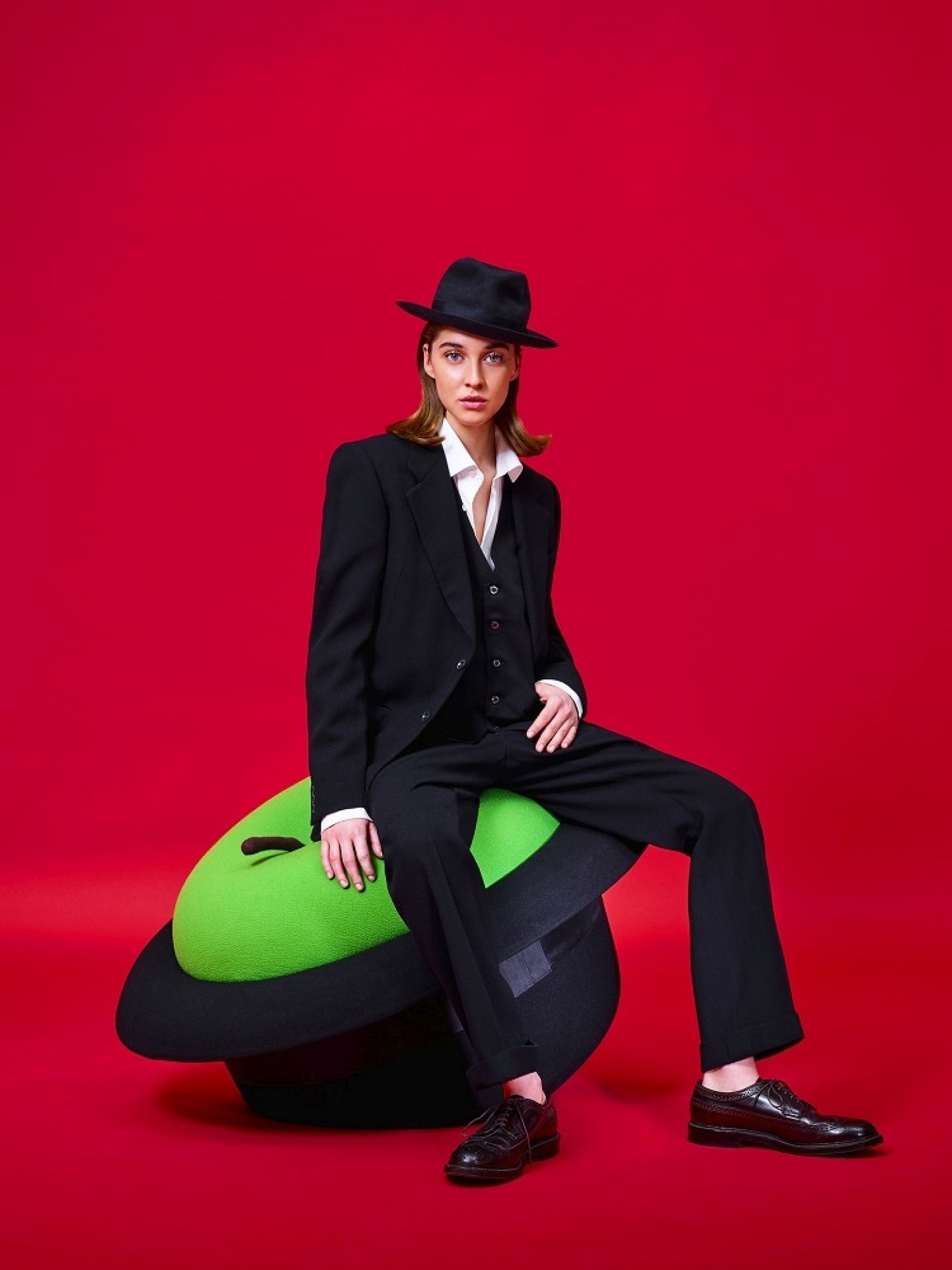 Frau sitzt auf grünem MagriTTA Sculpture-Sessel Pouf von Gufram. Designermöbel für Wohnzimmer und Büro.