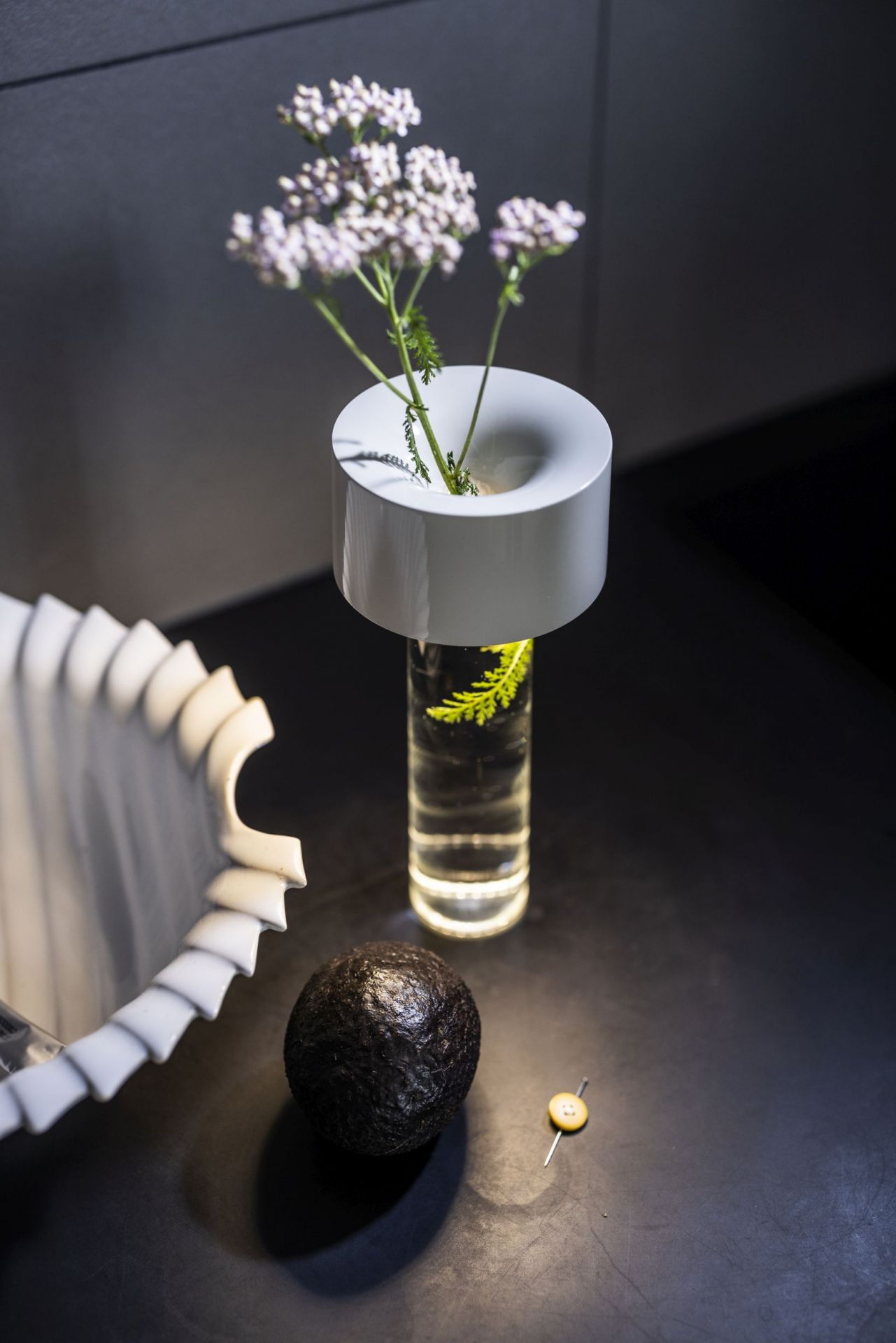 Detailaufnahme der modernen Tischleuchte von Foscarini mit Blumen in einem Glasgefäß.