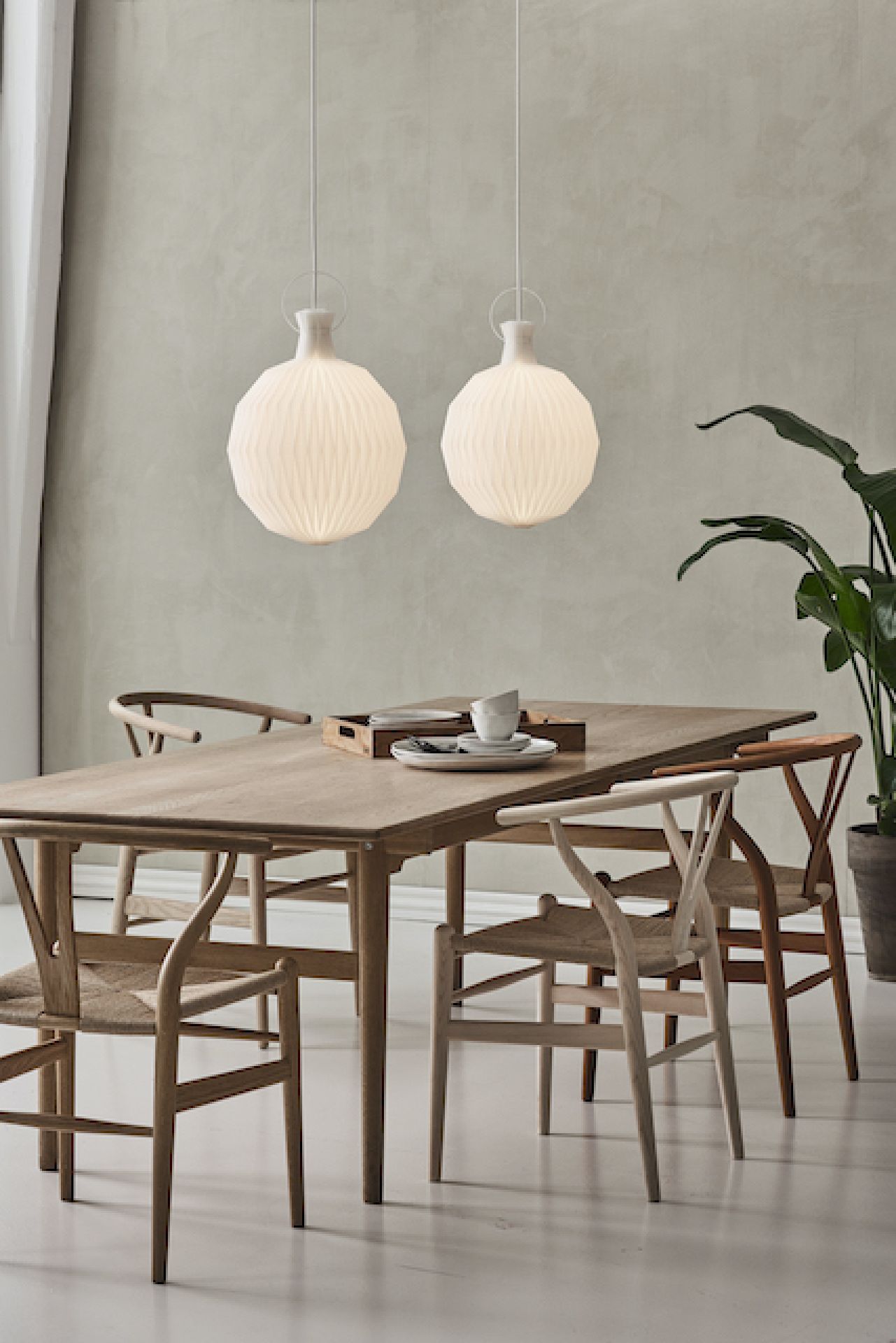 Zwei Model 101 Pendelleuchten von Le Klint mit Papierschirm über einem Esstisch.