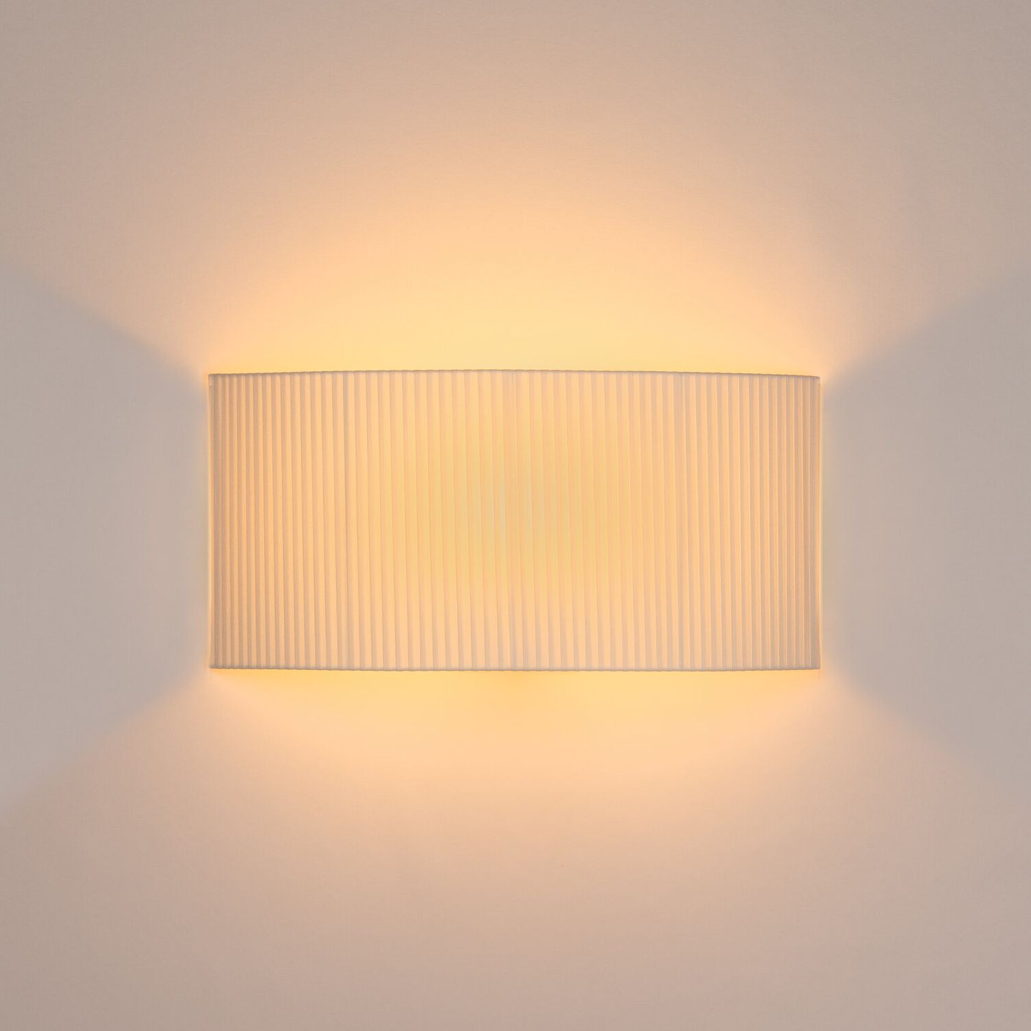 Nahaufnahme der leuchtenden, rechteckigen Santa & Cole Wandleuchte Comodín mit plissiertem Schirm.