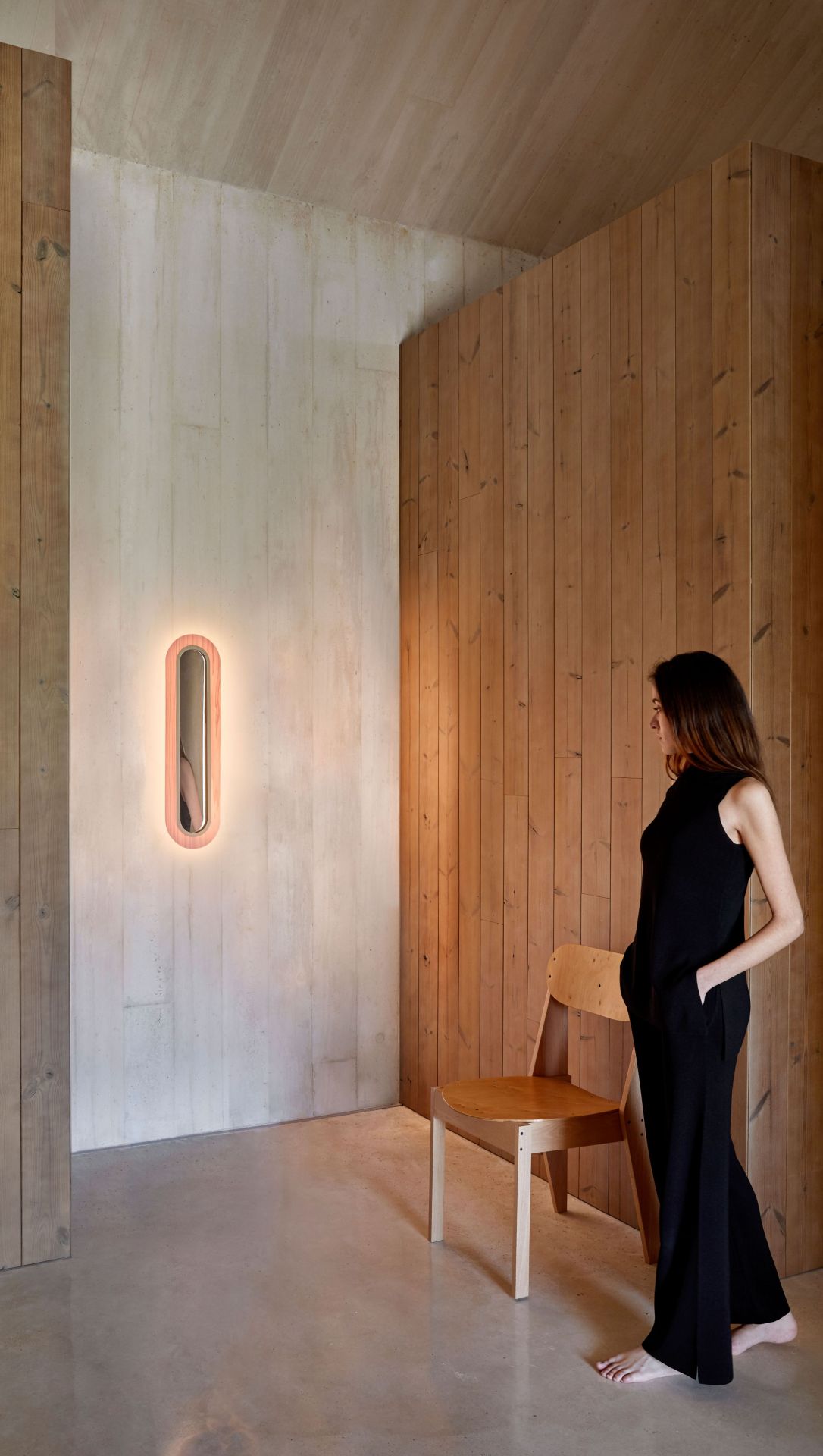 Lens LED Wandleuchte von LZF Lamps: Ovaler Metallring in Gold und Hellrosa an der Wand.