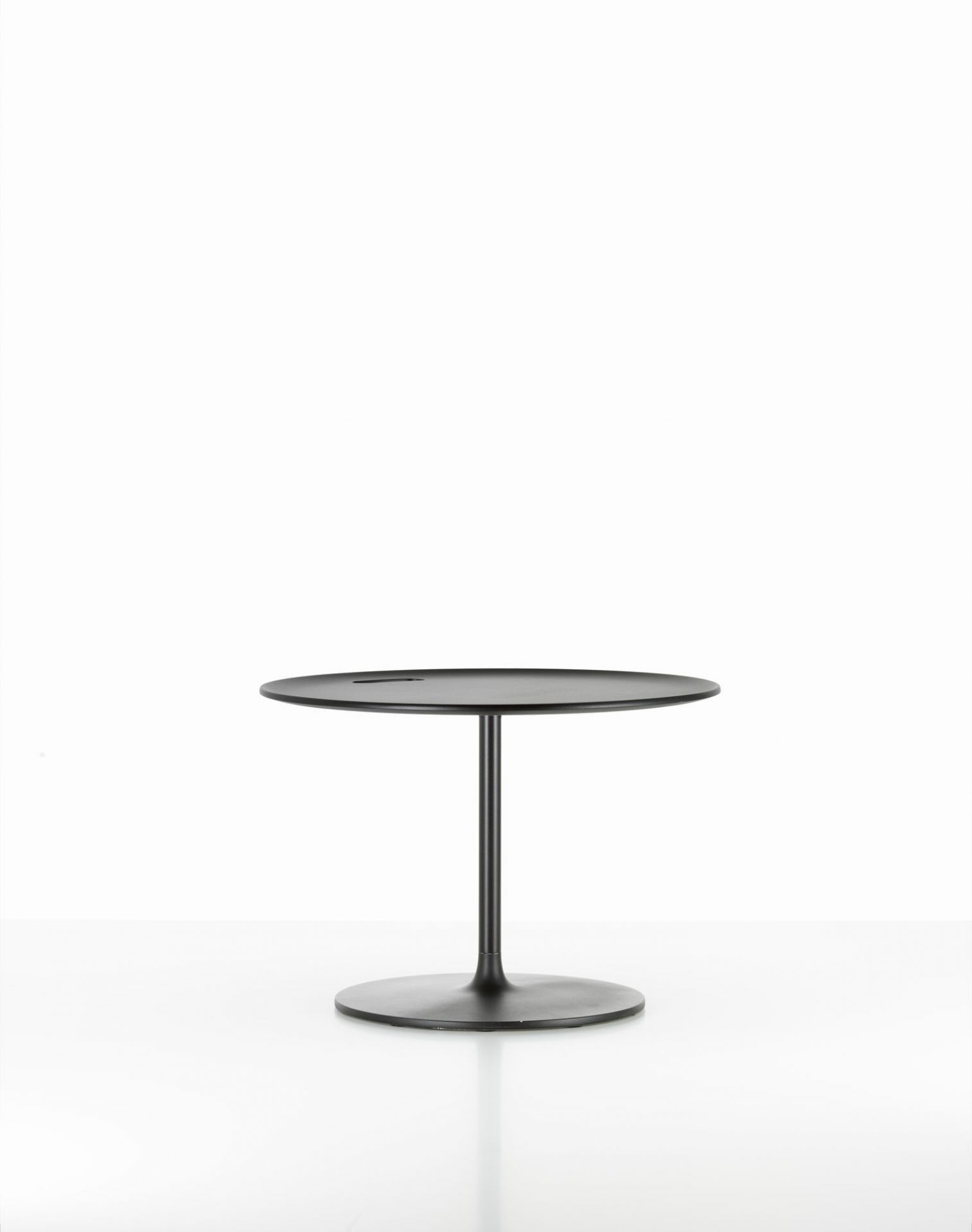 Schwarzer Vitra Beistelltisch "Occasional Low Table" mit runder Tischplatte und Fuß auf weißem Hintergrund.