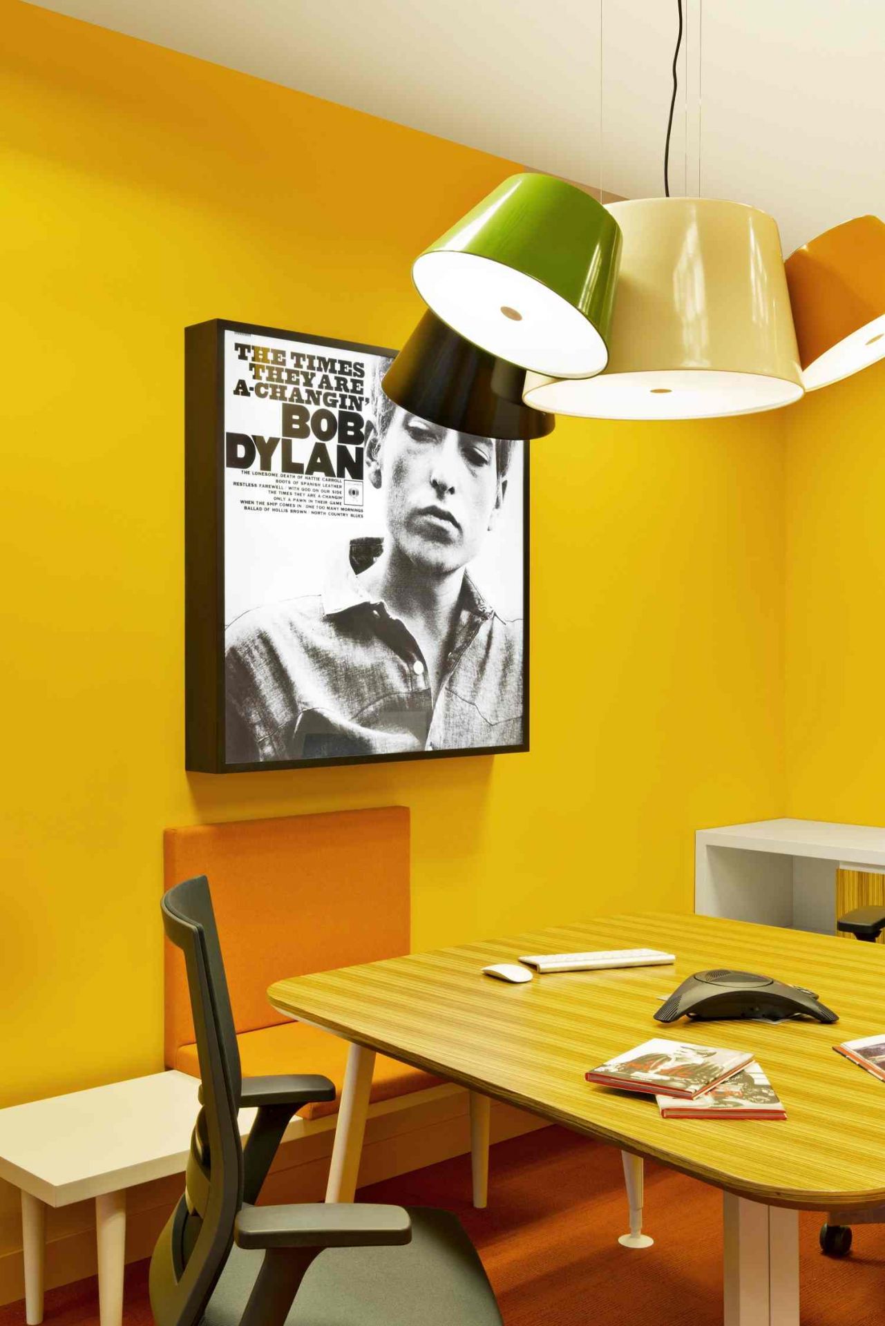 Tam Tam 3 LED Pendelleuchte von Marset in einem Büro mit gelber Wand und Bob Dylan Poster.