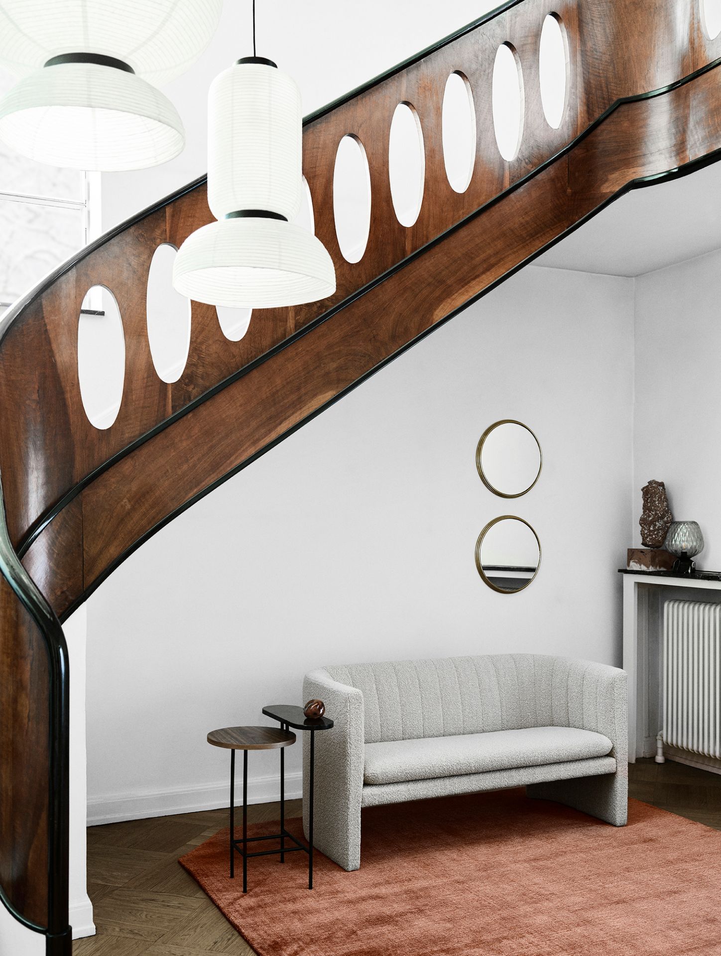 Graues Loafer Sofa, ein 2-Sitzer, vor einer Treppe und auf einem roten Teppich.