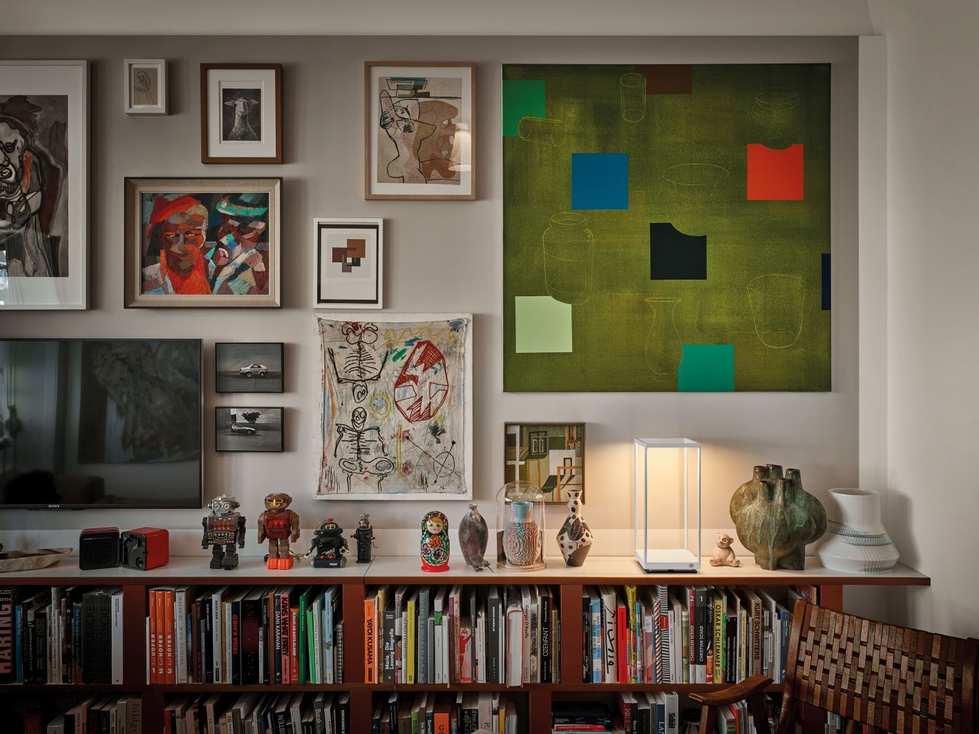 Weiße Reflex² Tischleuchte von Serien Lighting auf Regal mit Büchern und Kunstwerken. Modernes Design.