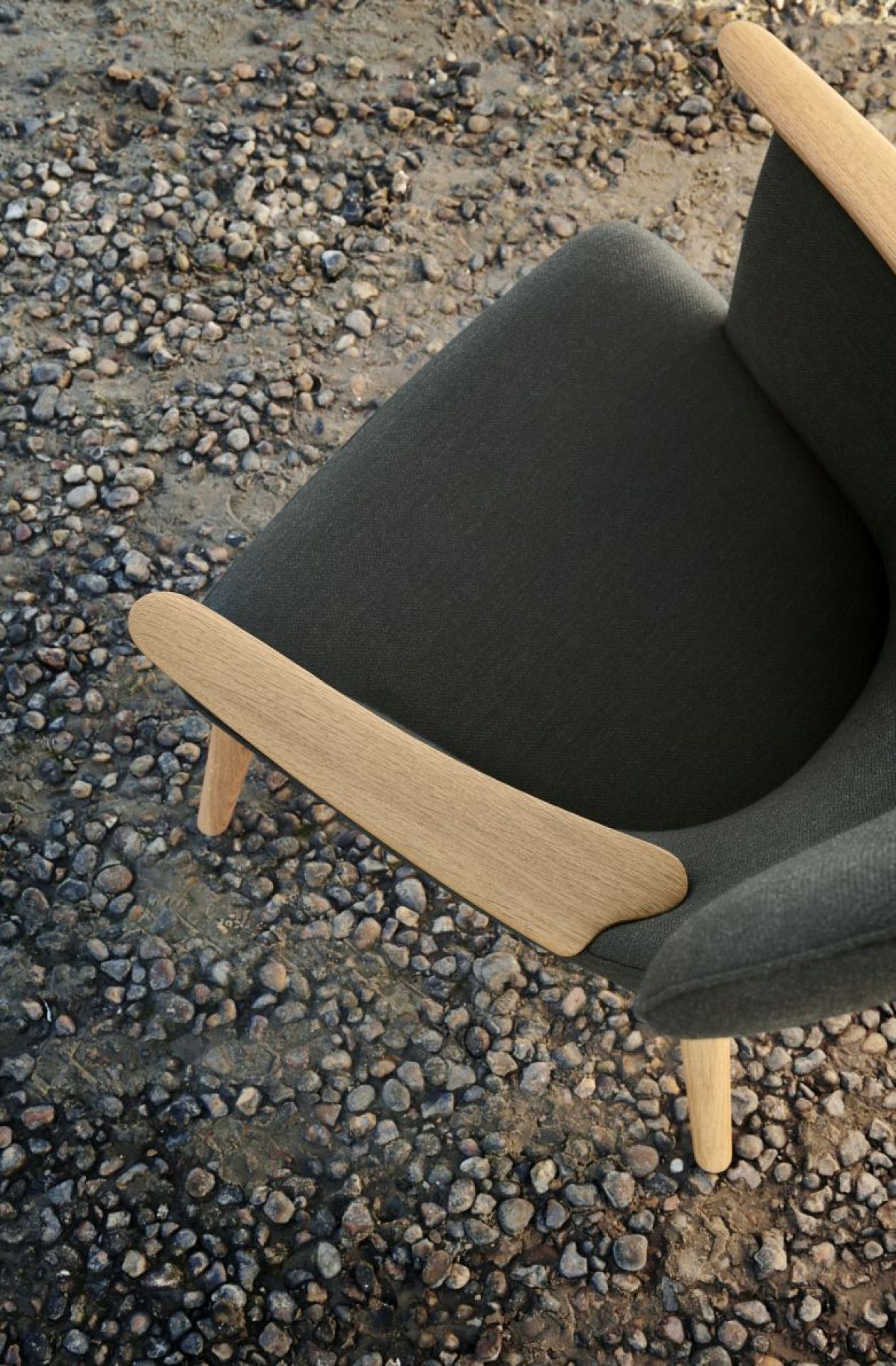 Detailaufnahme des CH78 Mama Bear Sessels von Carl Hansen & Søn mit Holzarmlehnen.