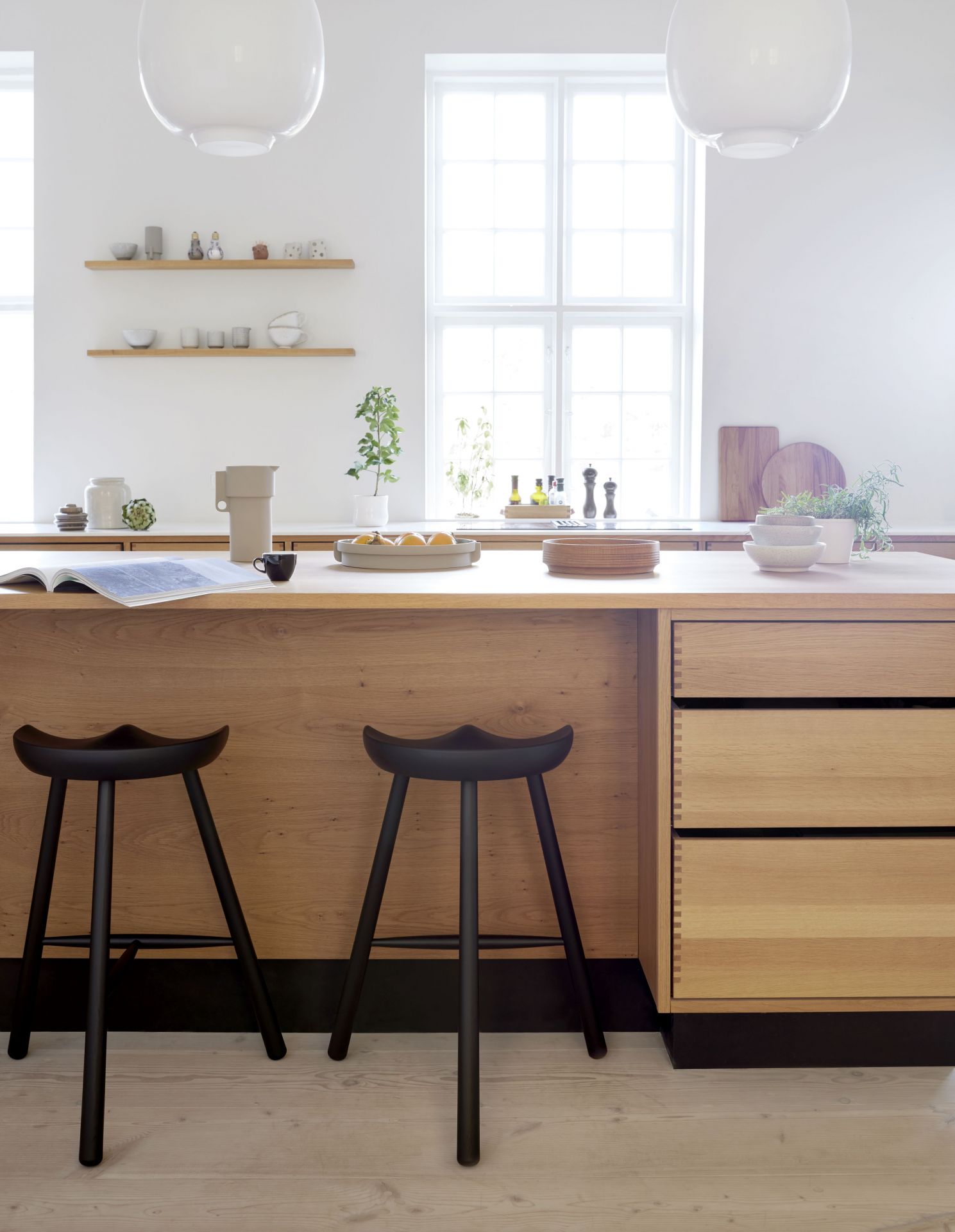 Zwei Shoemaker Chair No. 68 Barhocker aus geräucherter Eiche vor einer Kücheninsel.