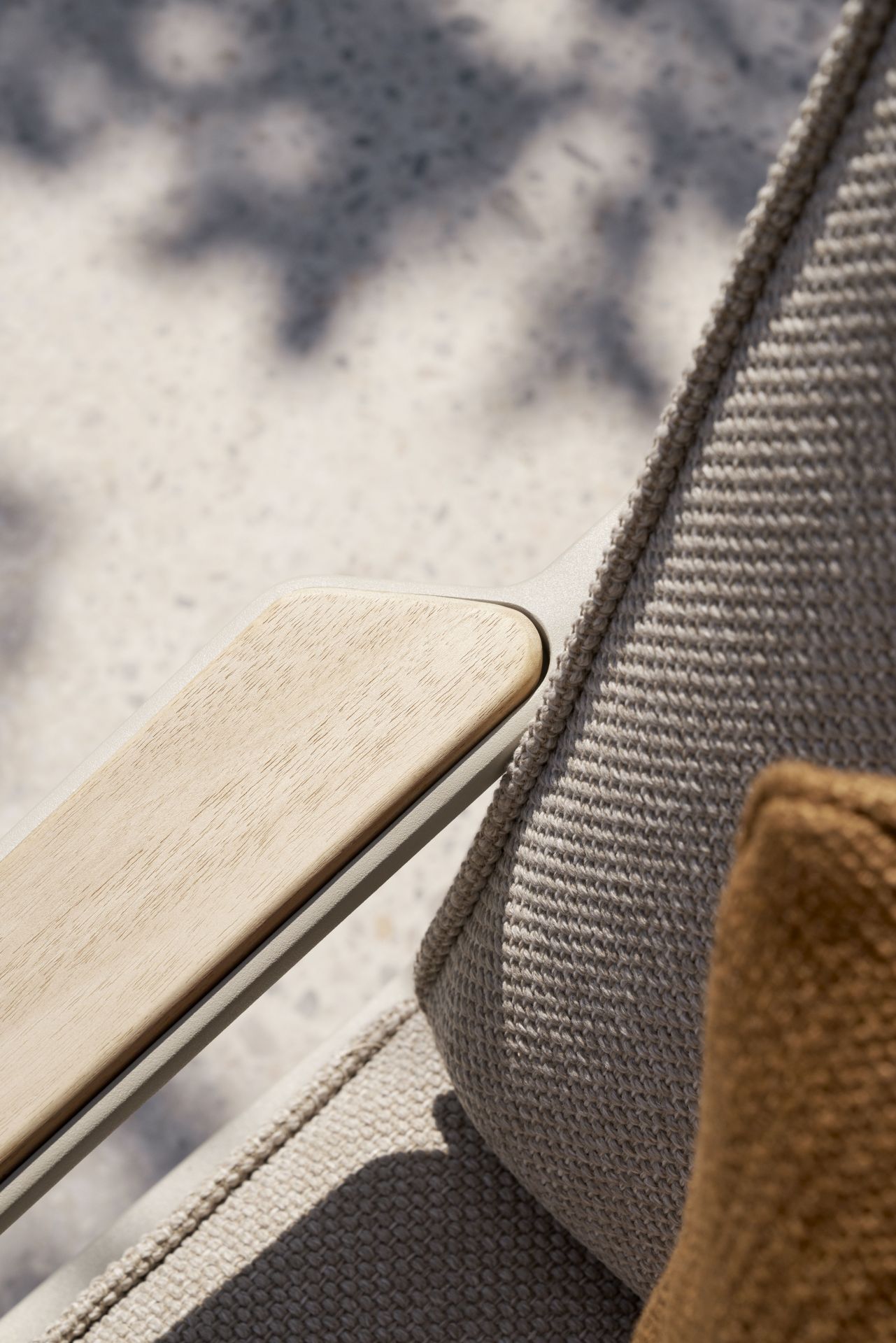 Detailaufnahme des Vipp Open-Air Lounge Stuhls mit Armlehne aus Holz und beigem Outdoor-Stoff.