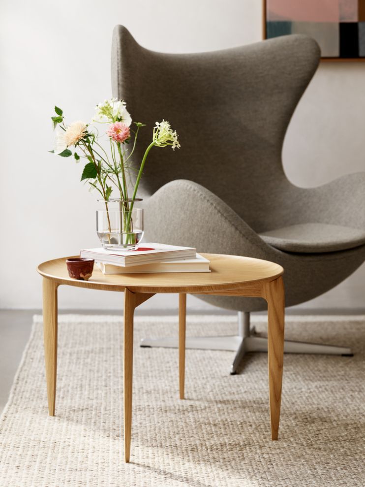 Fritz Hansen Tray Beistelltisch Ø60cm aus Eiche mit Blumen und Büchern im modernen Wohnzimmer.