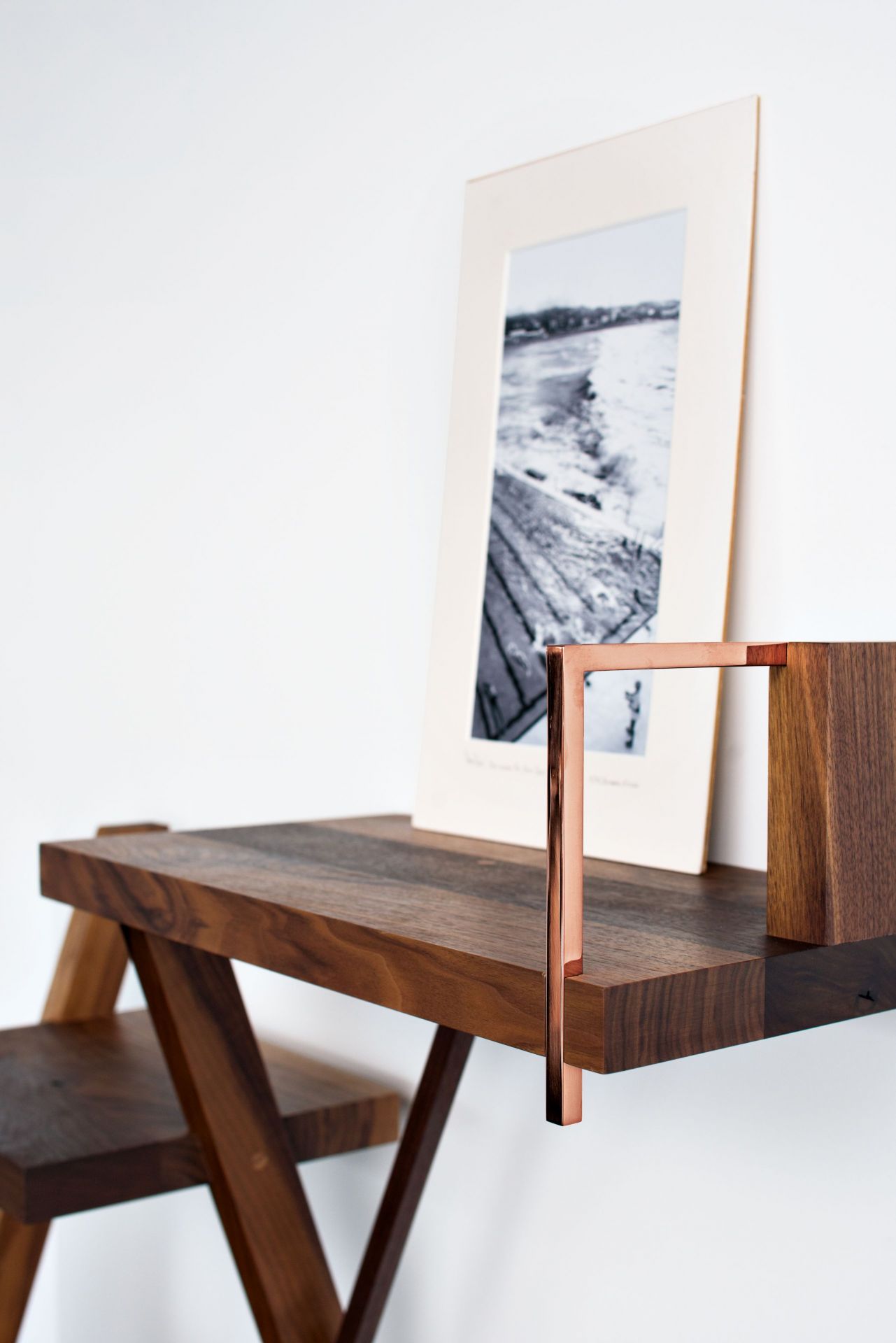 Elegantes Taidgh Wandregal aus Nussbaum mit modernem Design und dekorativem Rahmen.