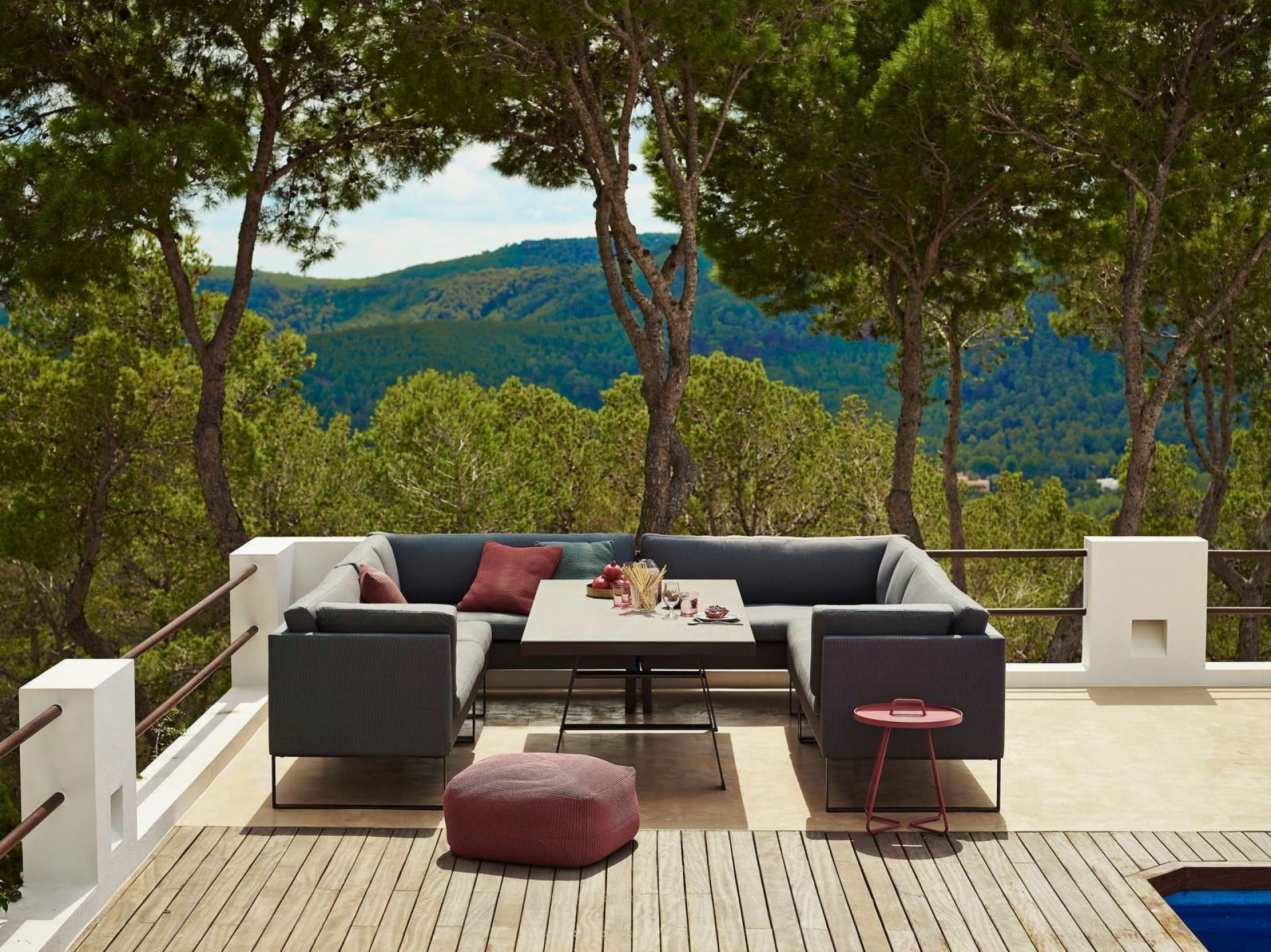 Cane-Line Flex Outdoor Sofa 2-Sitzer rechts auf Terrasse mit Blick in die Natur.