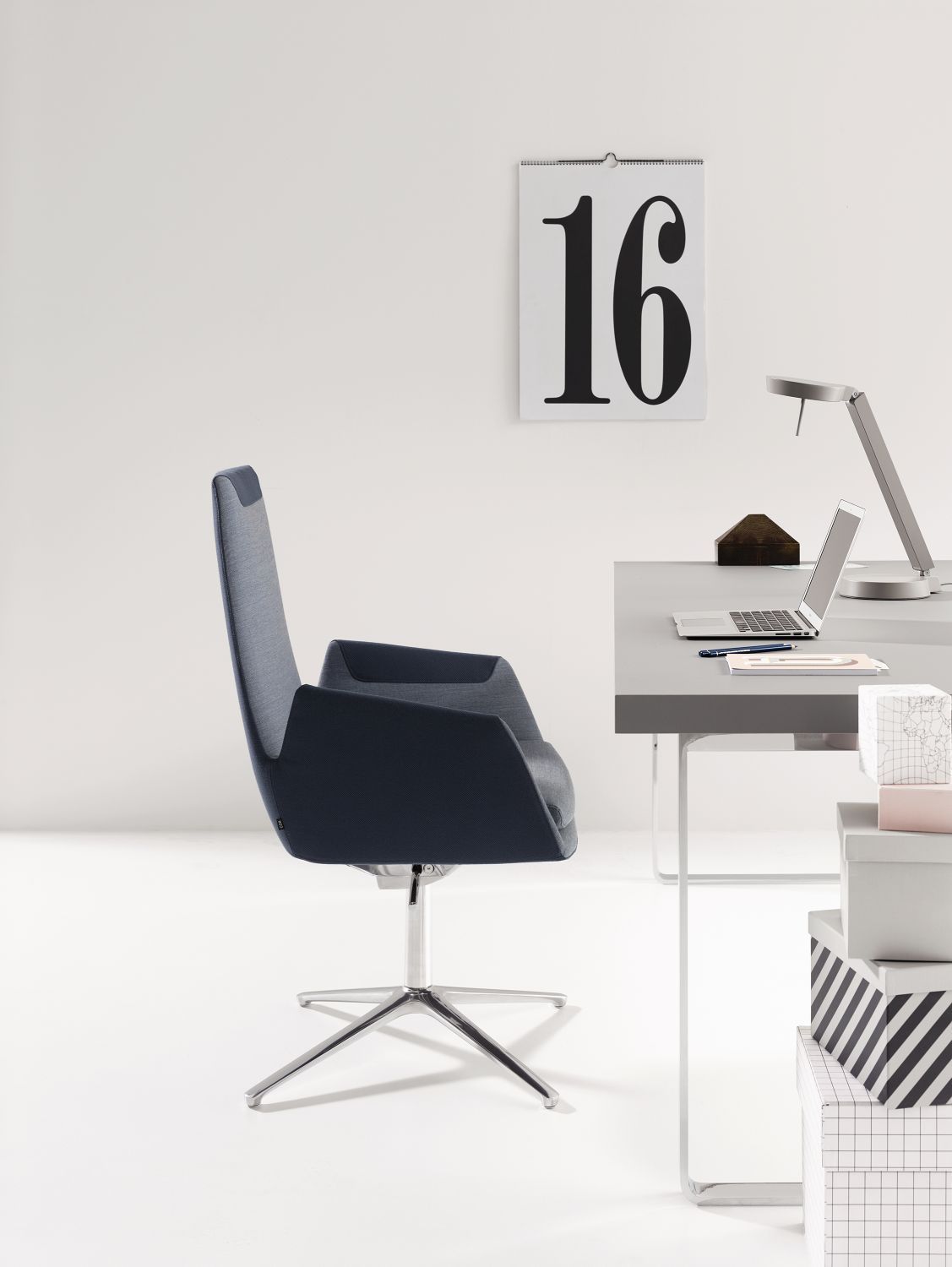 Cordia Drehstuhl mit hoher Rückenlehne, blauer Stoffbezug und silbernes Fußkreuz im Büro.