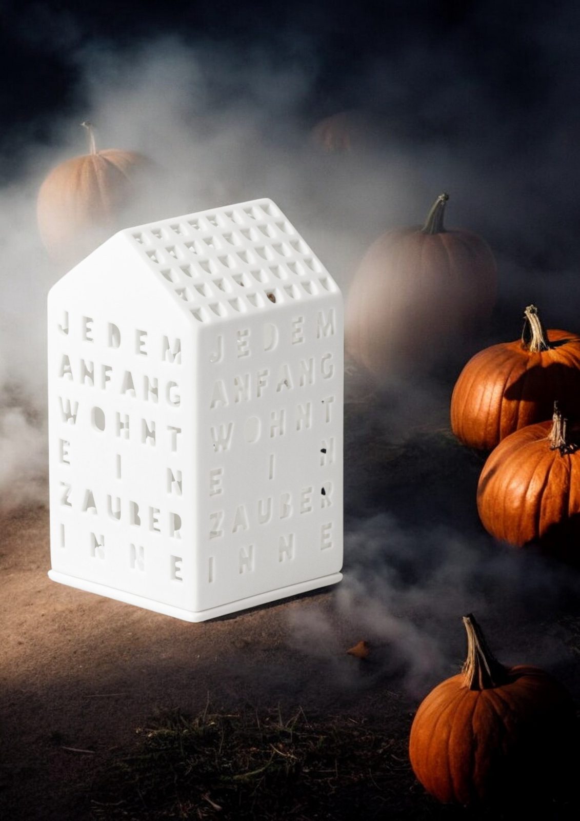 Lichthaus "Jedem Anfang wohnt ein Zauber inne" von Räder, weiße Keramik, umgeben von Kürbissen.