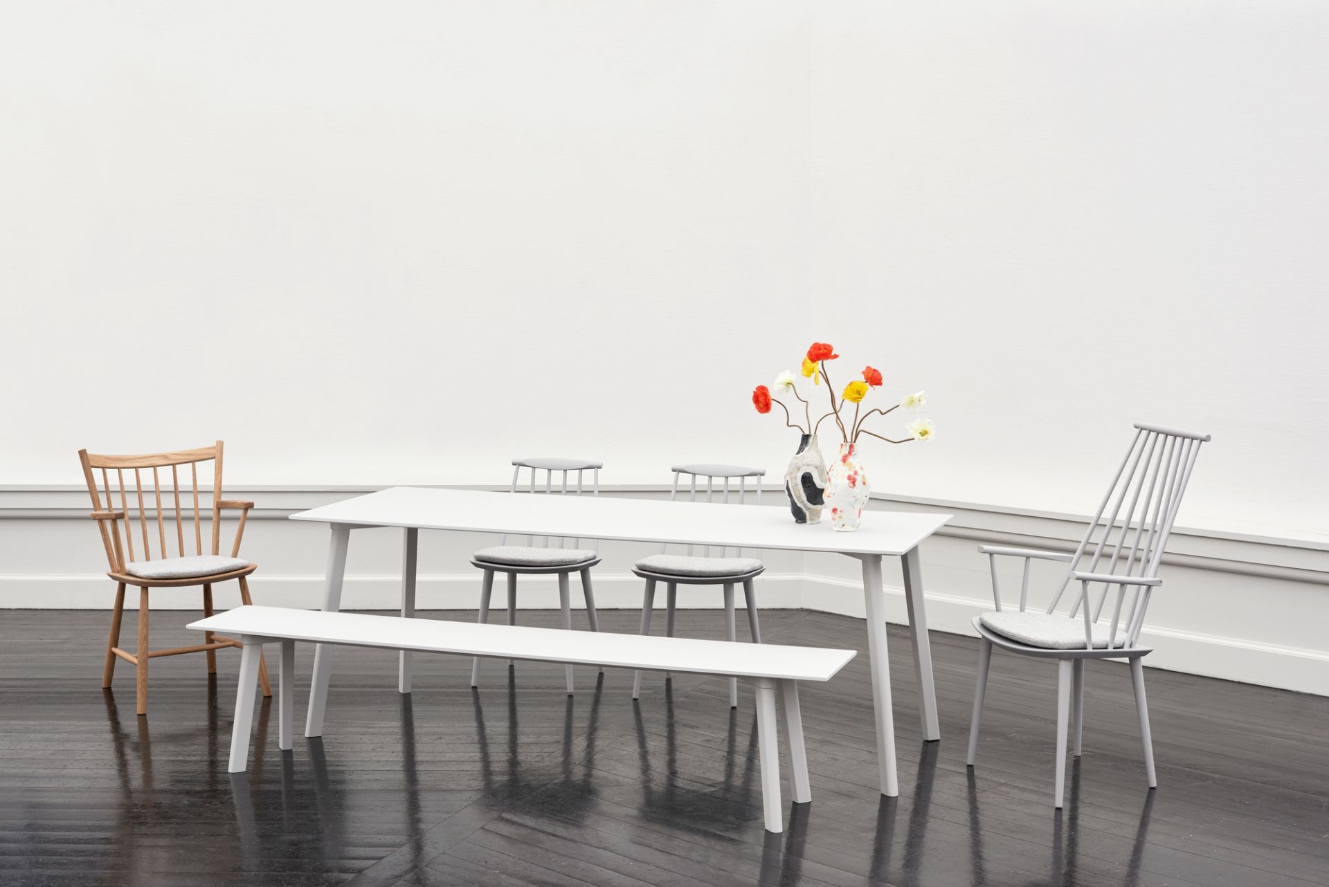 Esszimmer mit J42 Stuhl von Hay, Tisch, Bank und Hockern in minimalistischem Design.