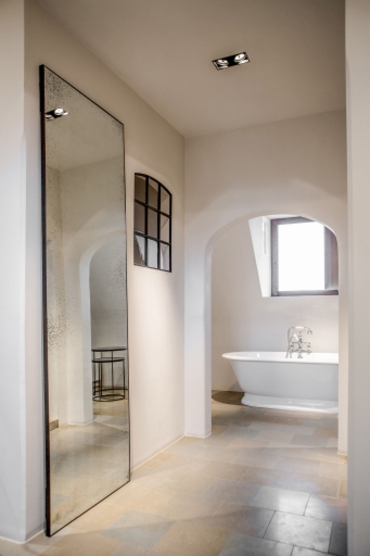 Ethnicraft Wandspiegel "medium aged klar" im Badezimmer mit freistehender Badewanne und Fenster.