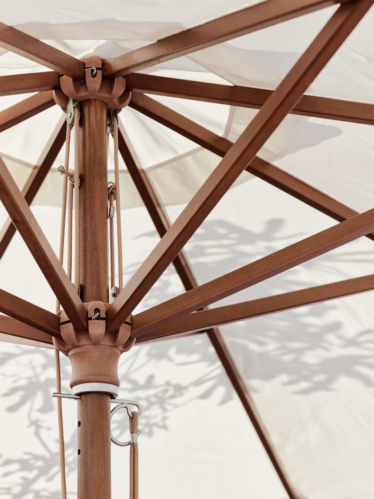 Detailaufnahme des Messina Sonnenschirms mit Holzgestell und off-white Bespannung.