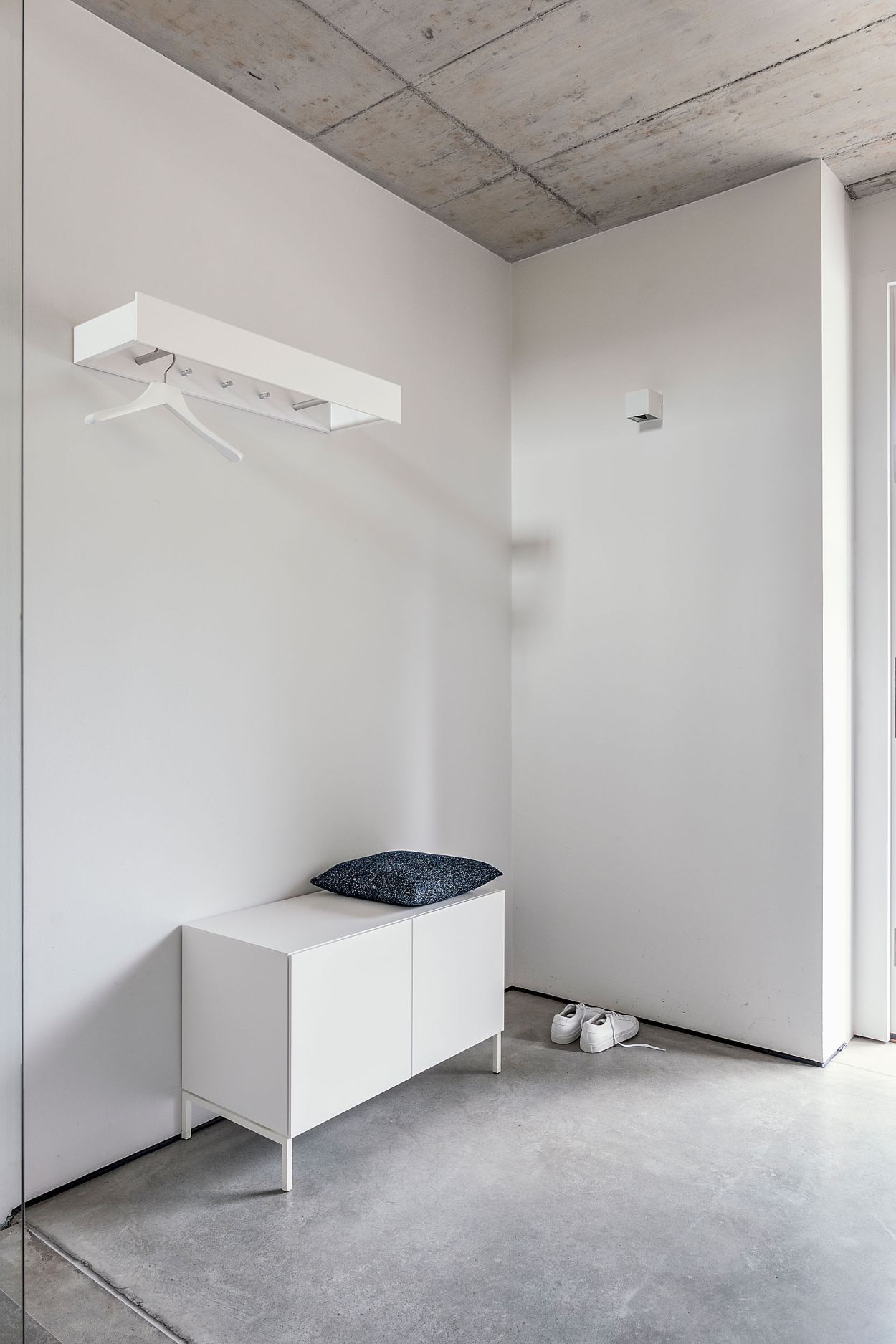 Hellele Urban Wandgarderobe von Schönbuch mit zwei Stangen und drei Haken über weißem Schuhschrank.