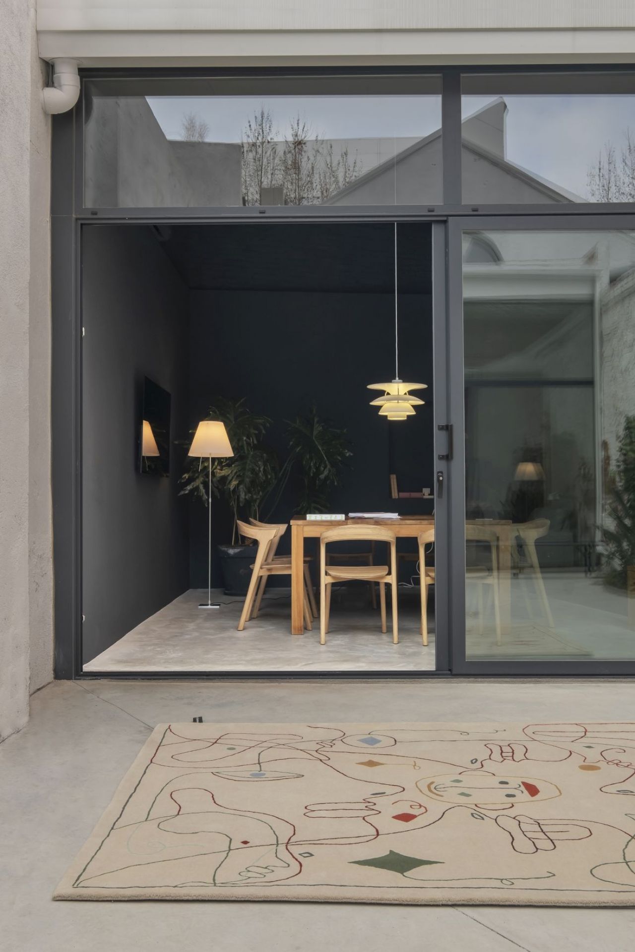 Nanimarquina Teppich Silhouette: Beige Outdoor Teppich mit abstraktem Muster vor modernem Wohnraum.