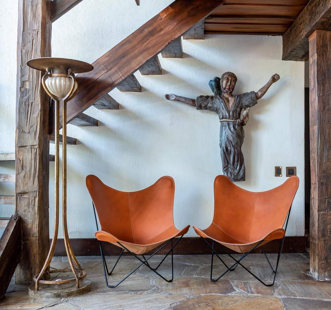 Zwei braune Pampa Mariposa Butterfly Sessel aus Leder mit schwarzem Gestell in einem Raum.