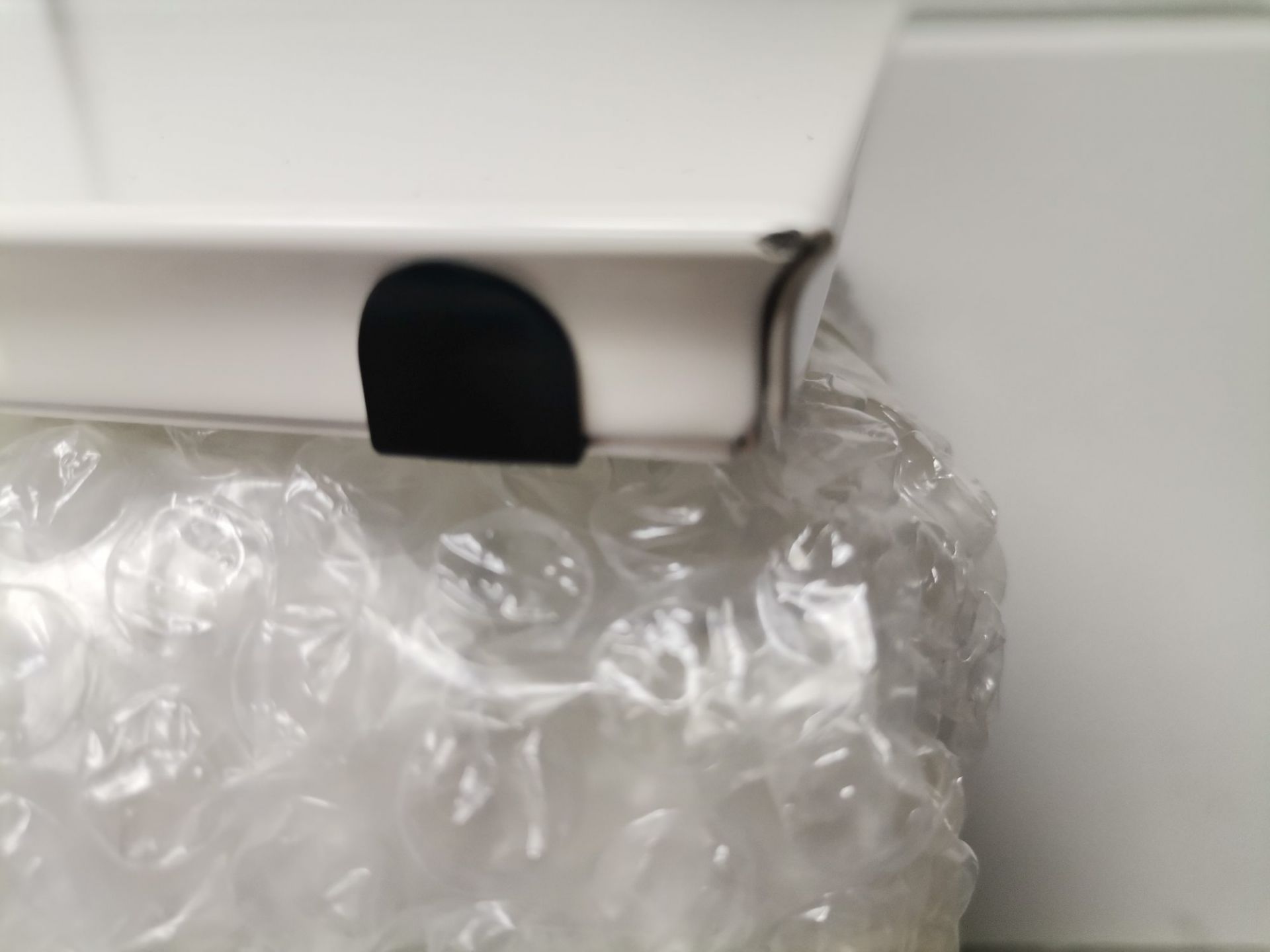 Nahaufnahme eines verpackten USM Haller Ersatzteils (Mängelexemplar) in Luftpolsterfolie, bereit für den Versand.