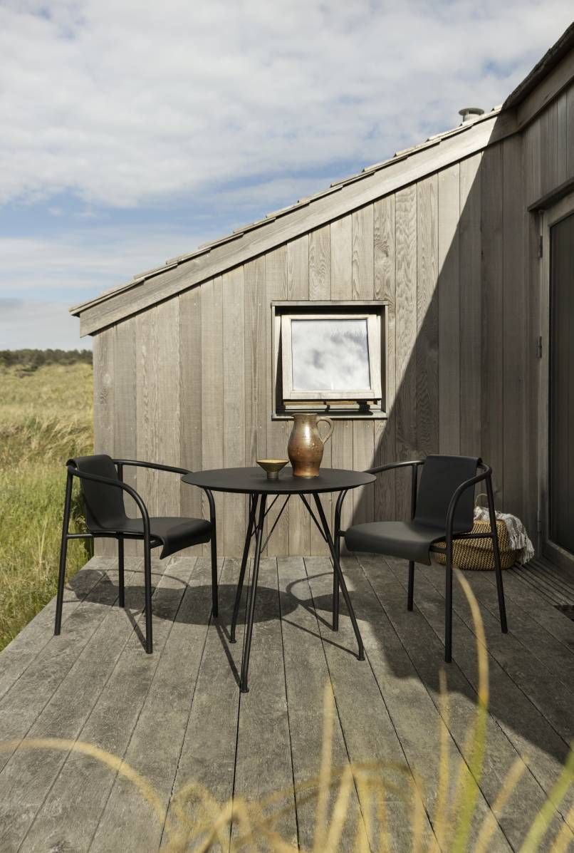 Nami Armlehnstuhl von Houe für den Außenbereich mit Tisch auf Holzterrasse.