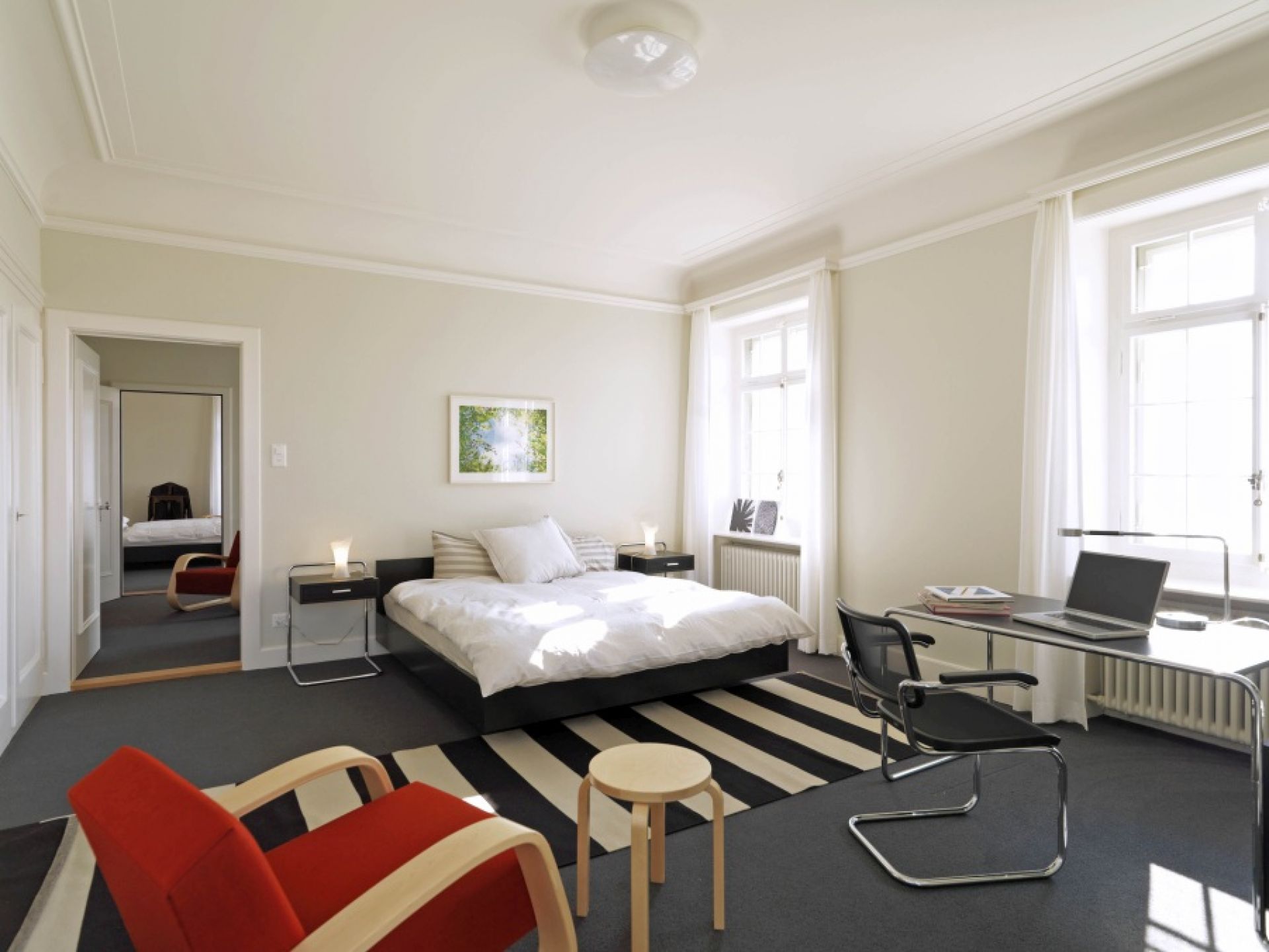 Schlafzimmer mit Thonet B 117 Beistelltisch mit Schublade neben dem Bett. Moderner Nachttisch.