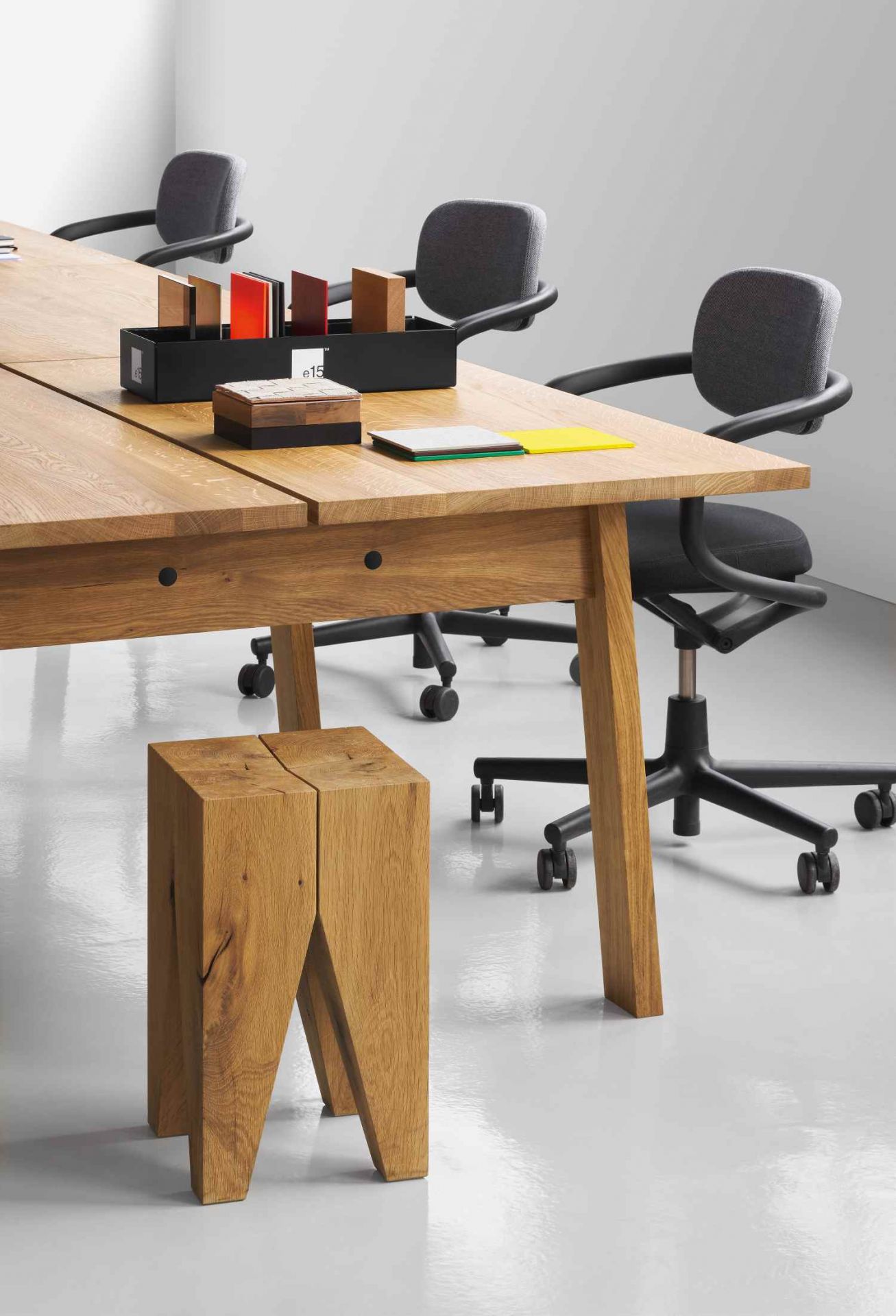 E15 Backenzahn Hocker aus Eiche neben einem Holztisch und Bürostühlen im Büro.