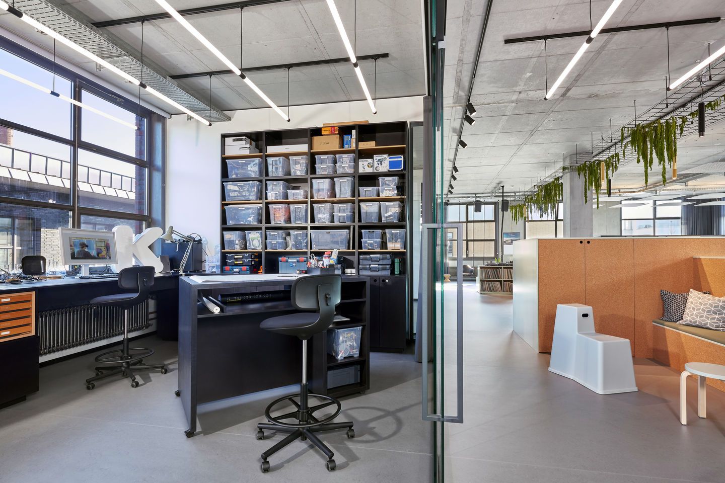 Büro mit zwei schwarzen Rookie High Bürodrehstühlen von Vitra an höhenverstellbaren Schreibtischen.